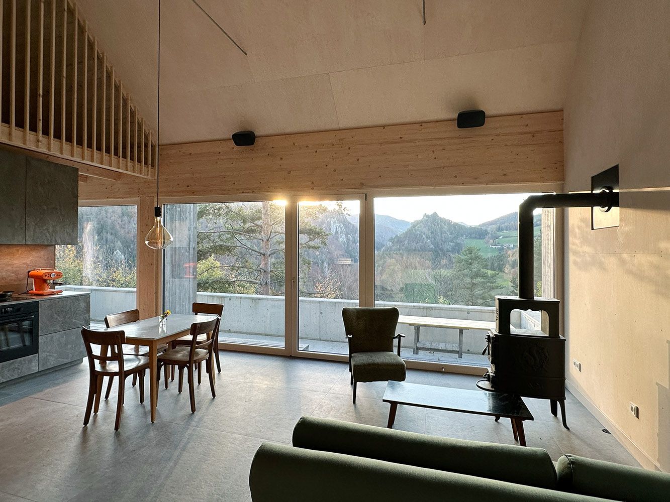 Moderner Wohn- und Essbereich mit großen Fenstern und Bergblick.