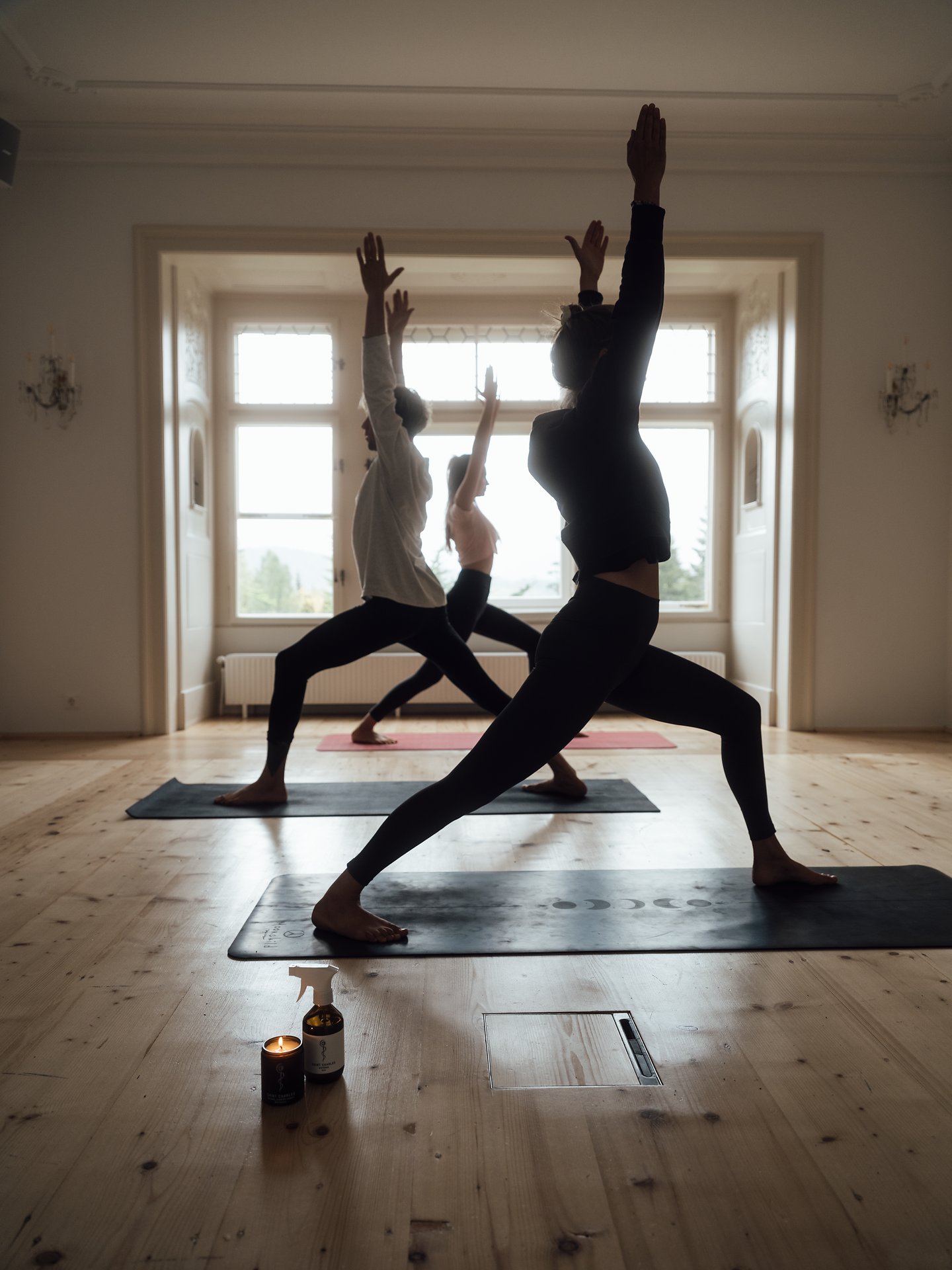 In einem lichtdurchfluteten Raum praktizieren Teilnehmer Yoga-Posen, während die sanften Bewegungen eine Atmosphäre der Ruhe und Harmonie schaffen. Die großen Fenster bieten einen atemberaubenden Blick auf die umliegenden Wiener Alpen, die in der Ferne majestätisch aufragen. Kerzenlicht und die Stille des Raumes laden dazu ein, den Moment zu genießen und die innere Balance zu finden.