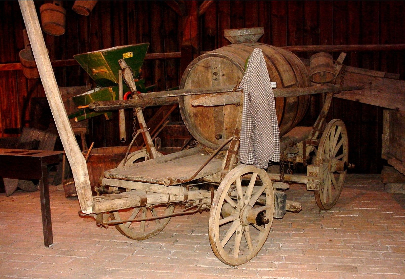 Alte Holzkutsche mit Fass in einem Museum.