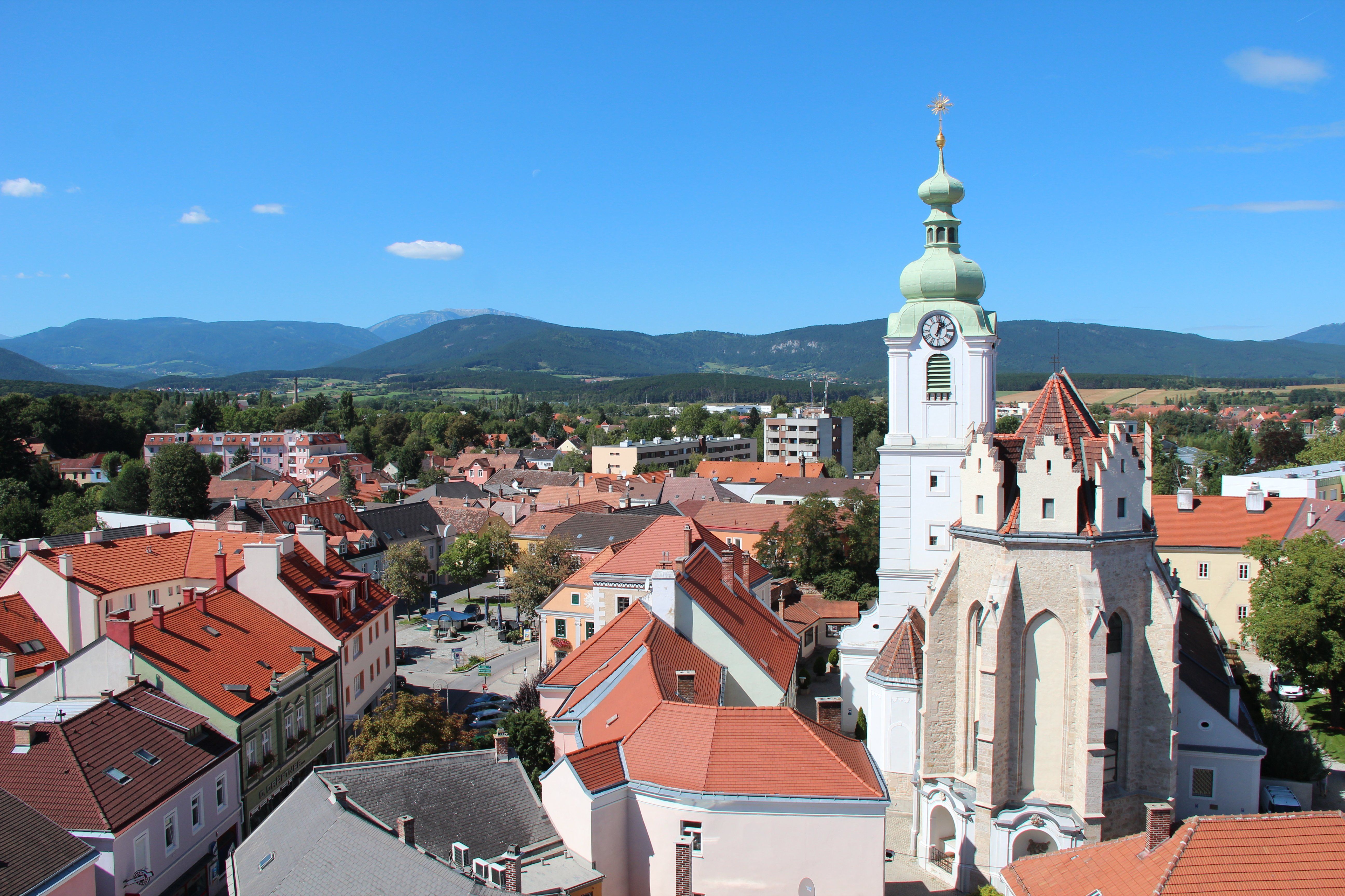 Panoramablick auf Neunkirchen mit Kirche und Bergen im Hintergrund.