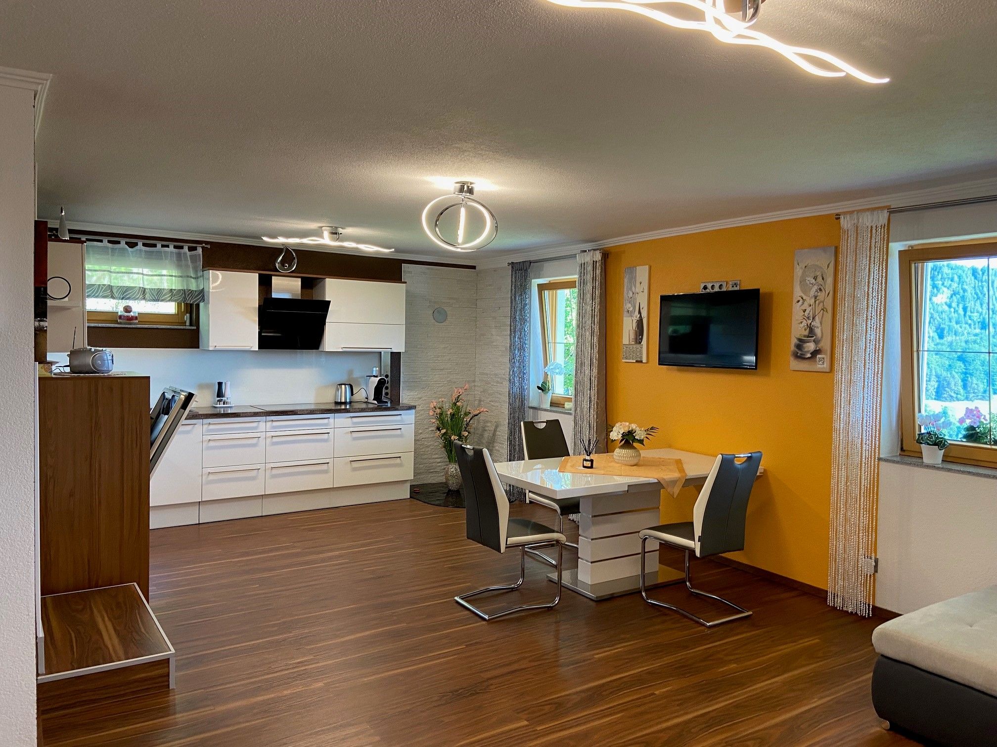 Moderne Wohnküche mit Esstisch, Stühlen und Einbauküche.