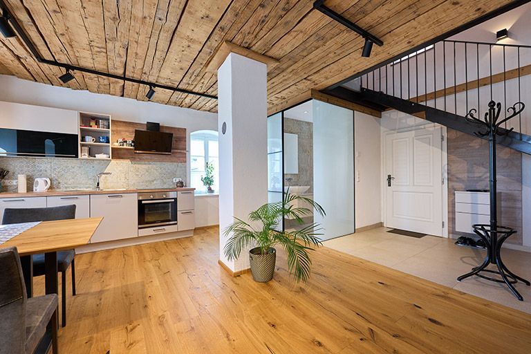 Moderne Küche mit Holzboden und -decke, Treppe und Pflanzen.