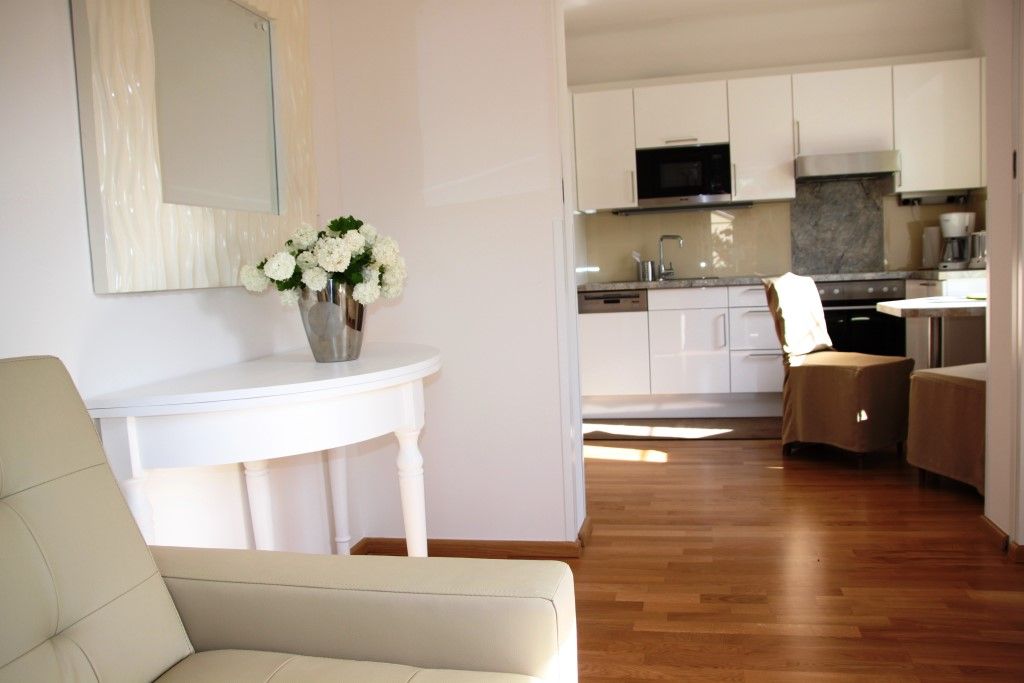 Innenansicht eines modernen Wohnbereichs mit Küche und Blumen auf einem Tisch.