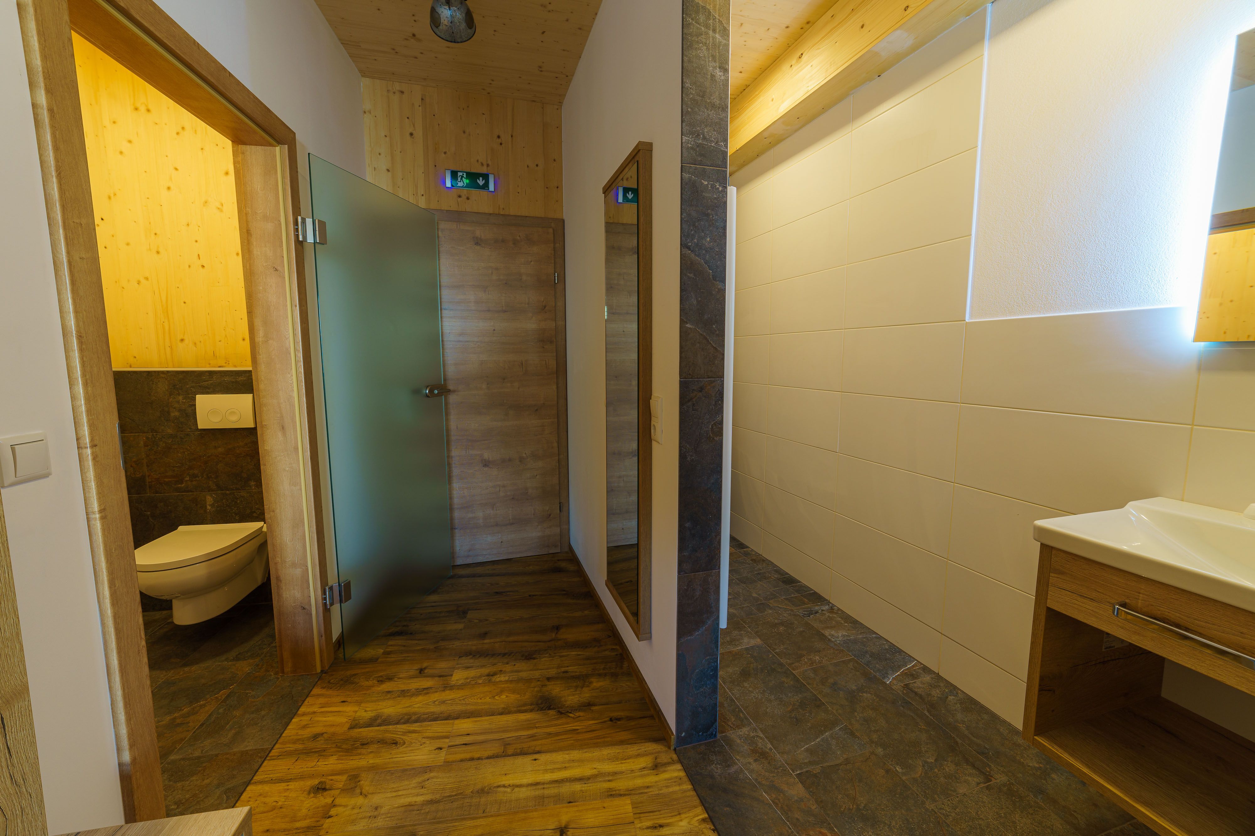 Modernes Badezimmer mit Holzelementen und Glasdetails.