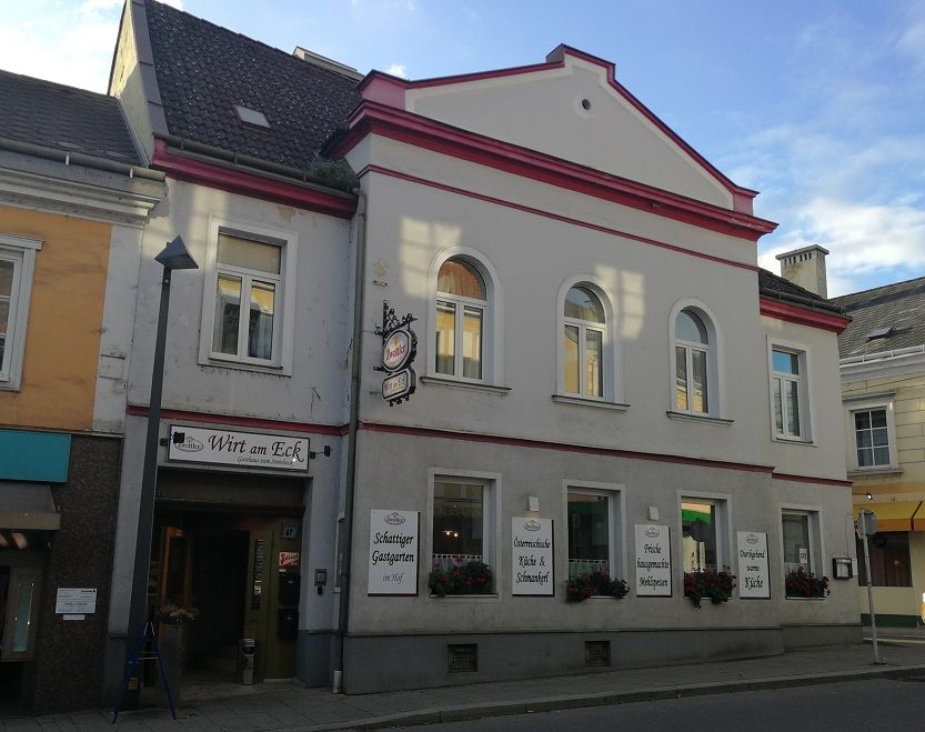 Gasthaus mit der Aufschrift 'Wirt am Eck' an einer Straßenecke.