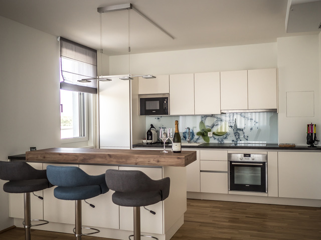 moderne Küche mit angrenzender Bar und Fenster 