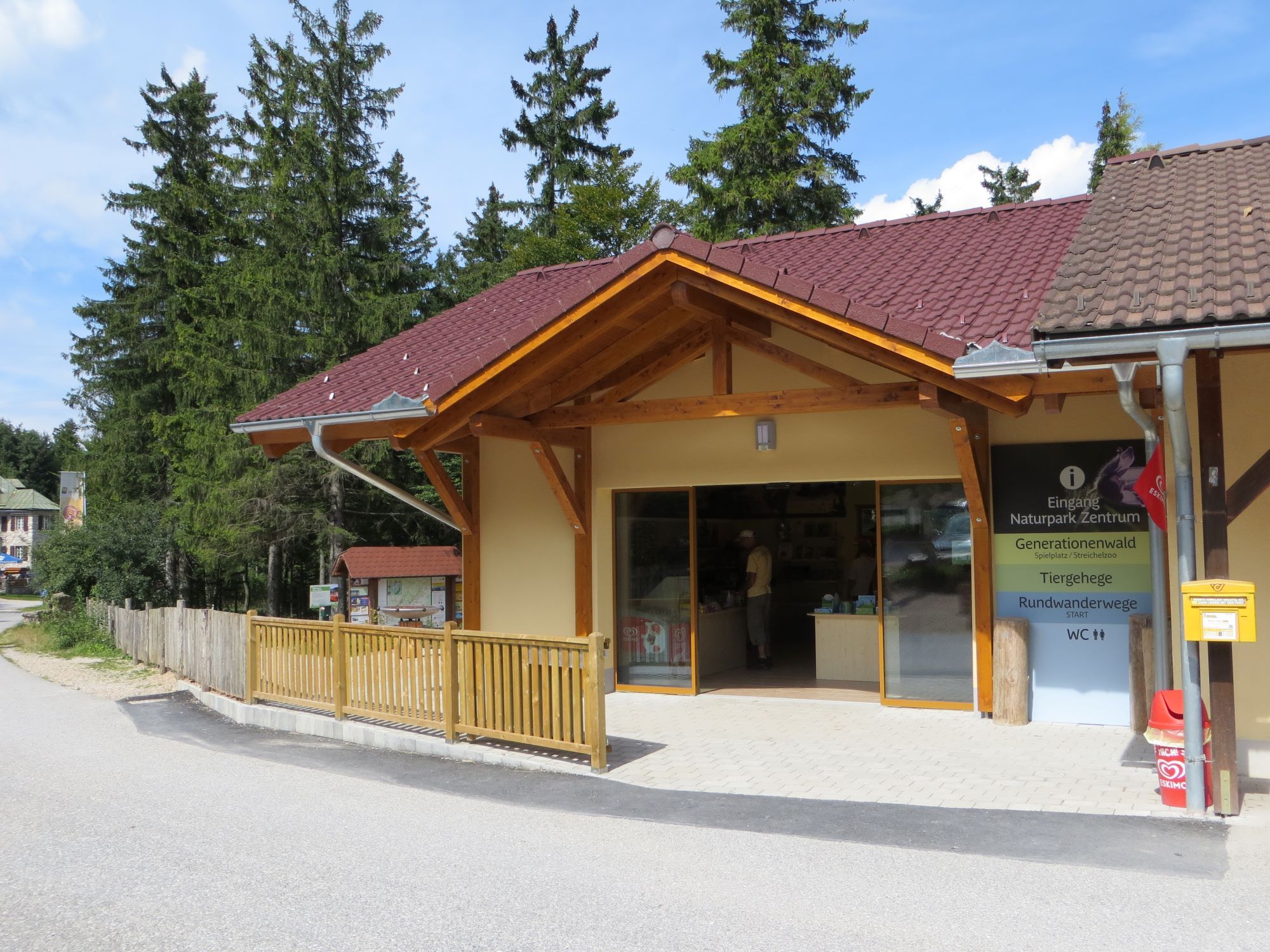 Eingang eines Naturpark-Zentrums mit Holzveranda und Informationsschild.