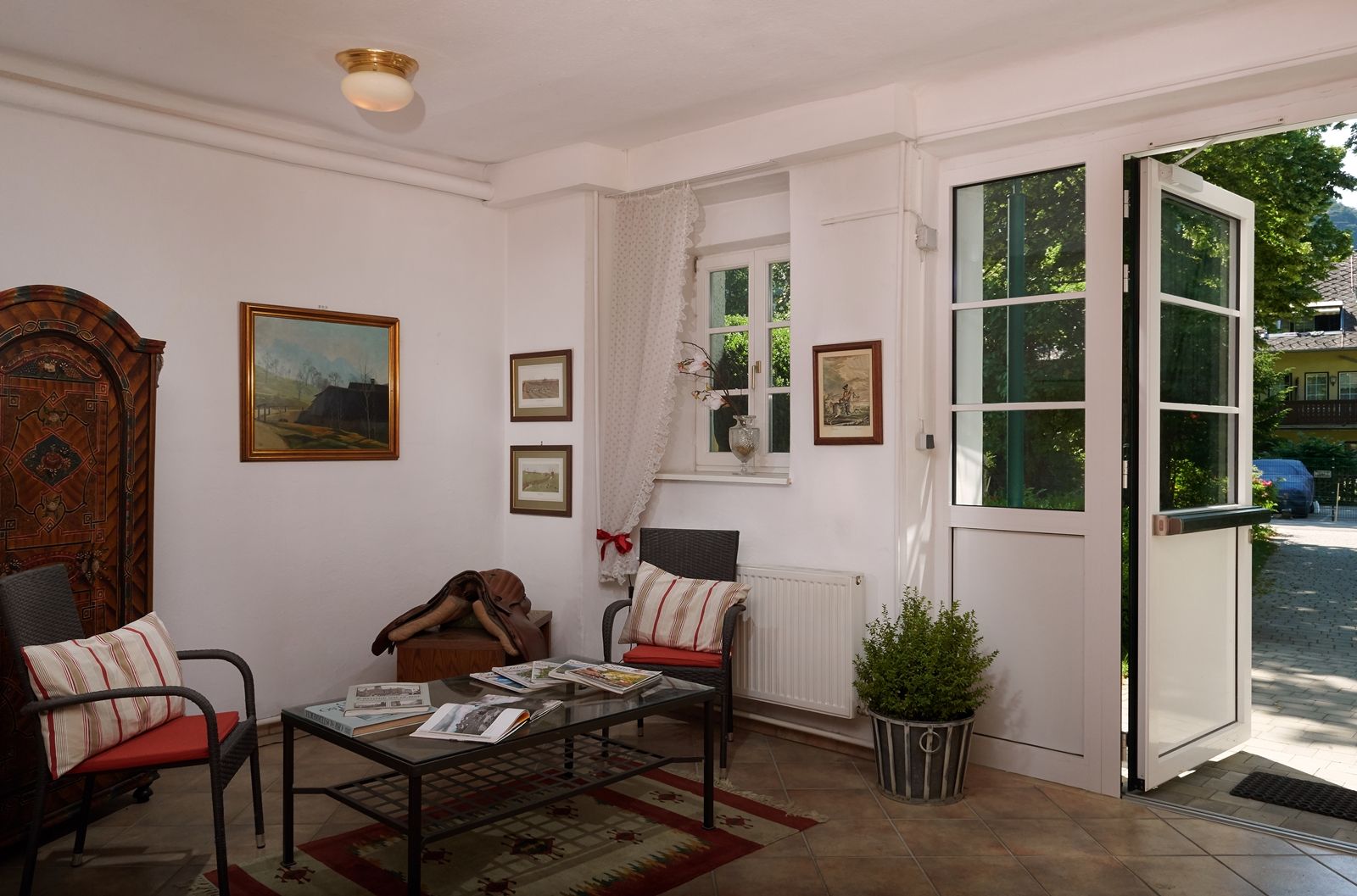 Gemütlicher Eingangsbereich mit Sesseln, Tisch und Dekorationen im Landhausstil.