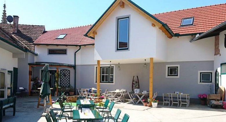 Innenhof eines Gasthauses mit Tischen und Stühlen im Freien.