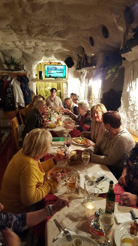 Gruppe von Menschen isst in einer gemütlichen Pizzeria.