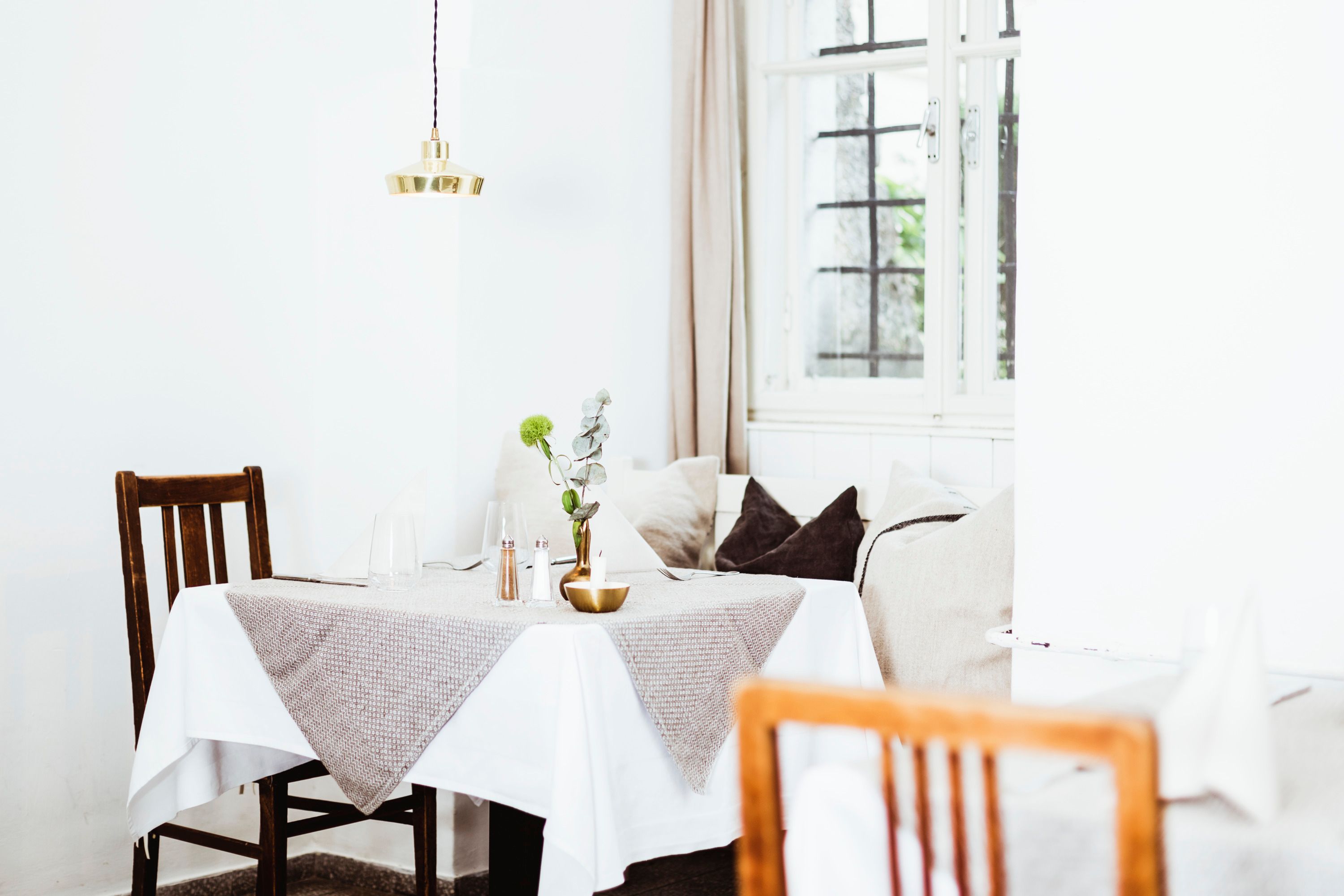 Gemütlich eingerichtetes Restaurant mit Holzmöbeln und Tischdeko.