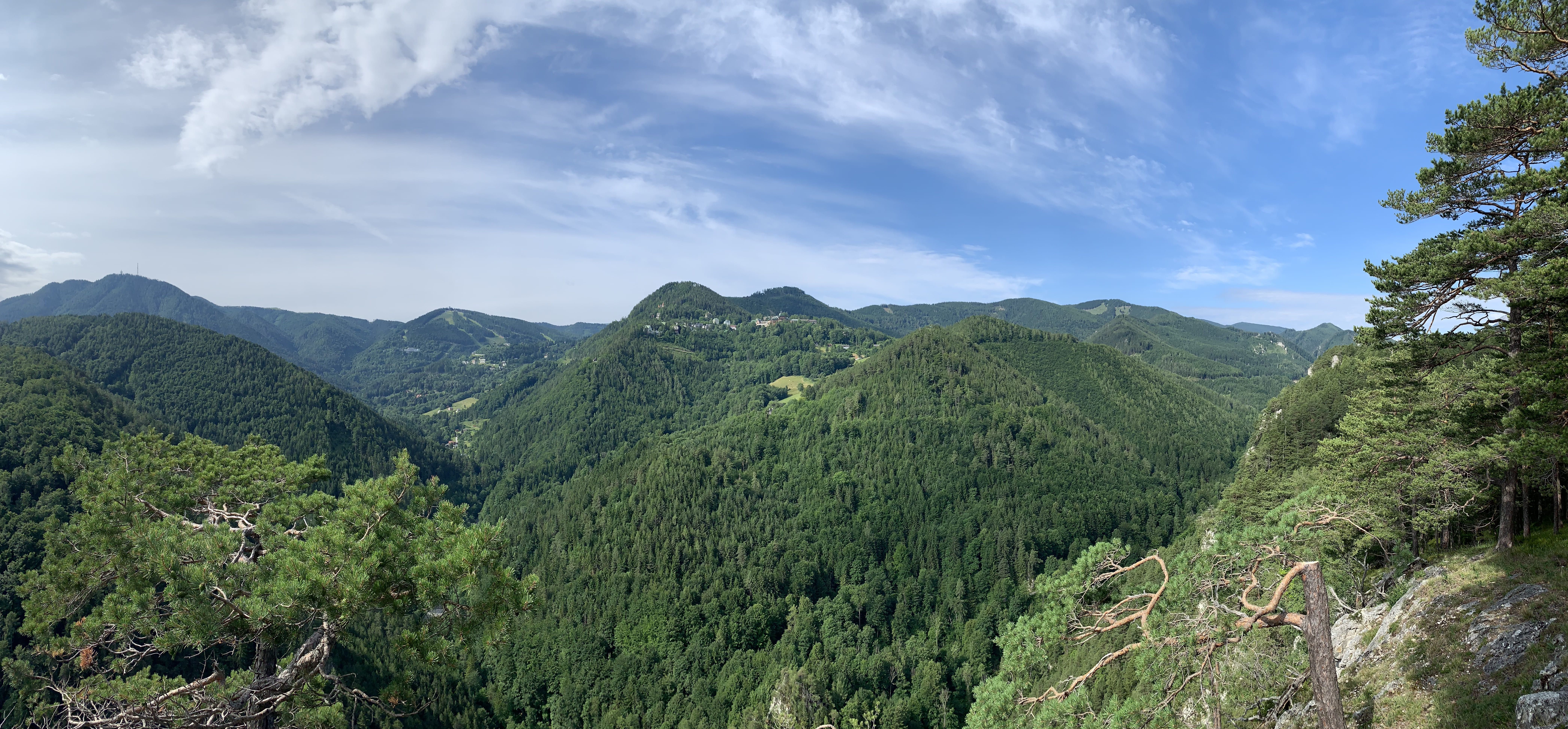 Panoramablick auf bewaldete Hügel und blauen Himmel nach Semmering