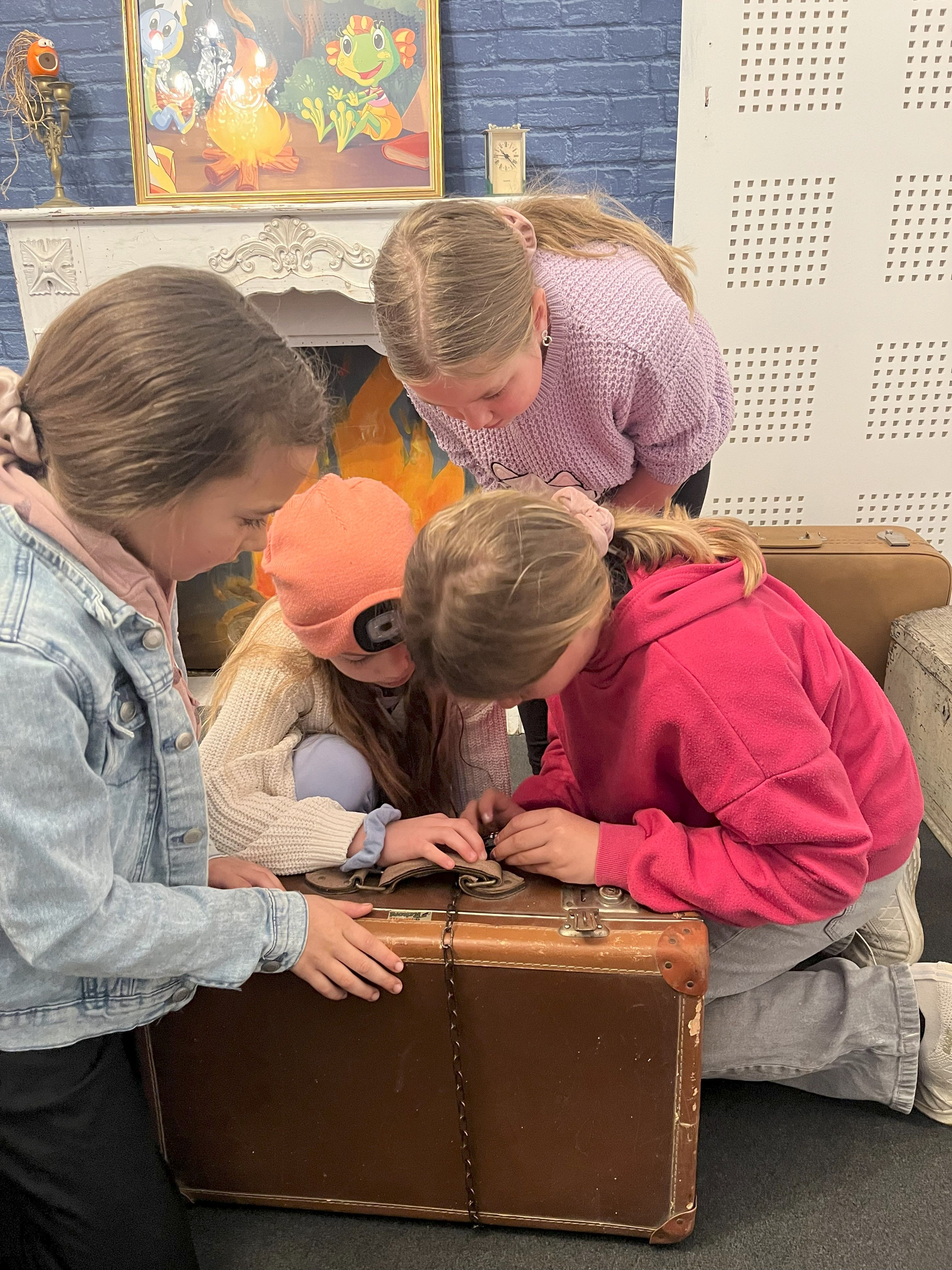 3 Kinder versuchen eine Koffer zu öffnen 