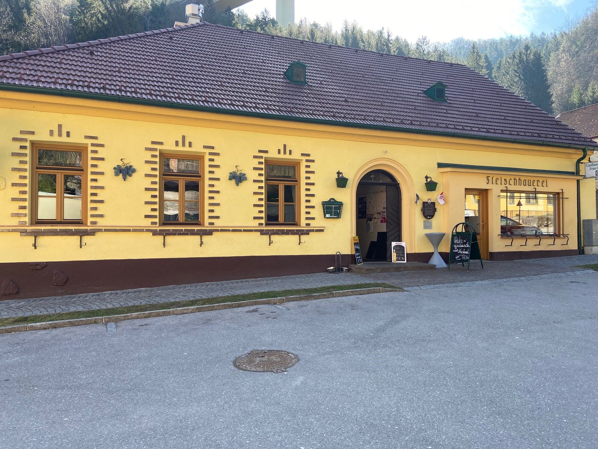 Gelbes Gebäude mit der Aufschrift 'Fleischhauerei' und einem Eingang.