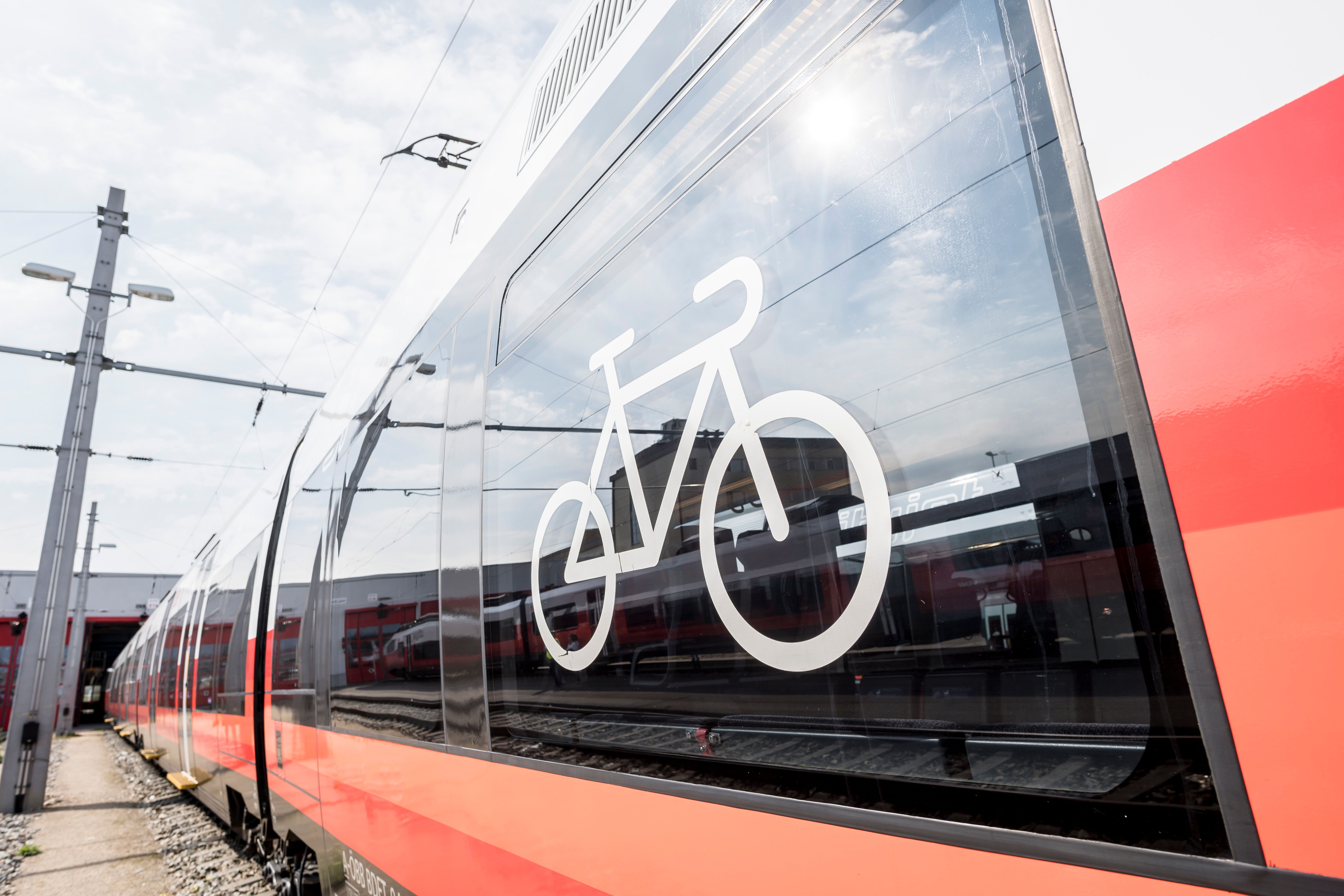 Nahaufnahme eines roten Zuges mit einem Fahrradsymbol auf dem Fenster.