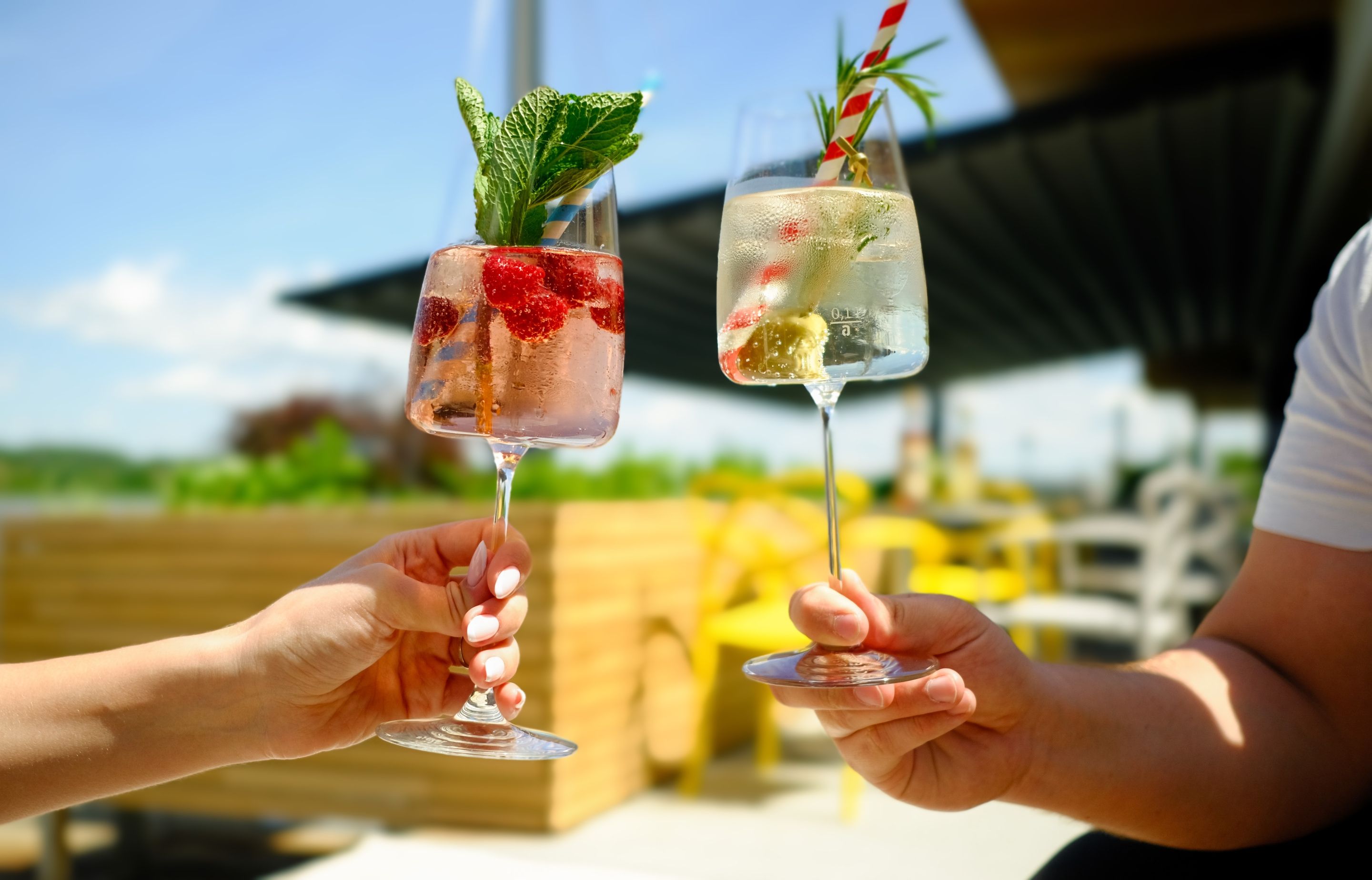 Zwei Menschen halten Weingläser mit gekühlten Getränken