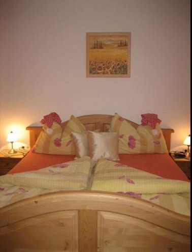 Gemütliches Gästezimmer mit Doppelbett, dekorativen Kissen und Nachttischlampen.