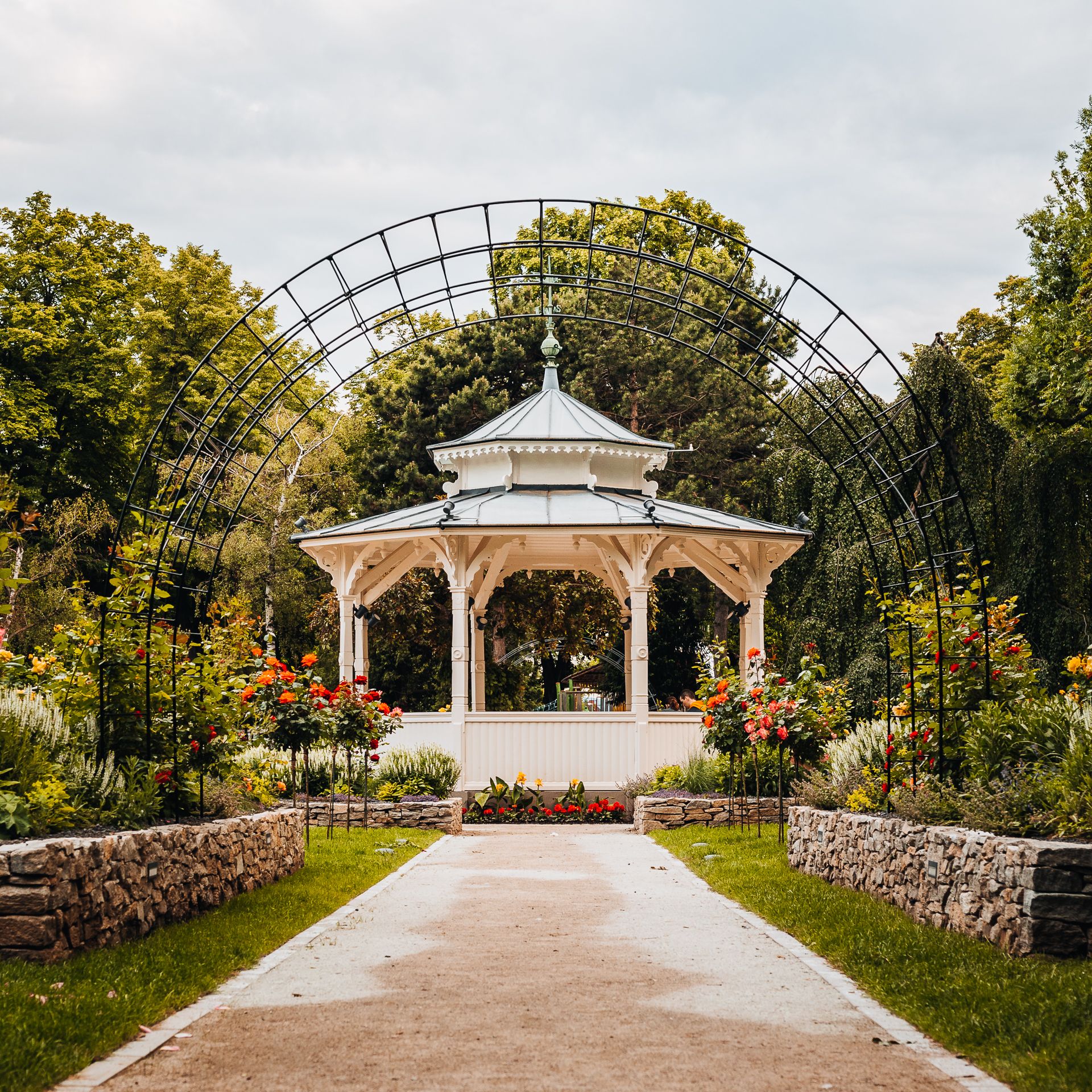 Grüner Stadtpark mit romantischem Pavillon, Rosengarten und Gitterbogen
