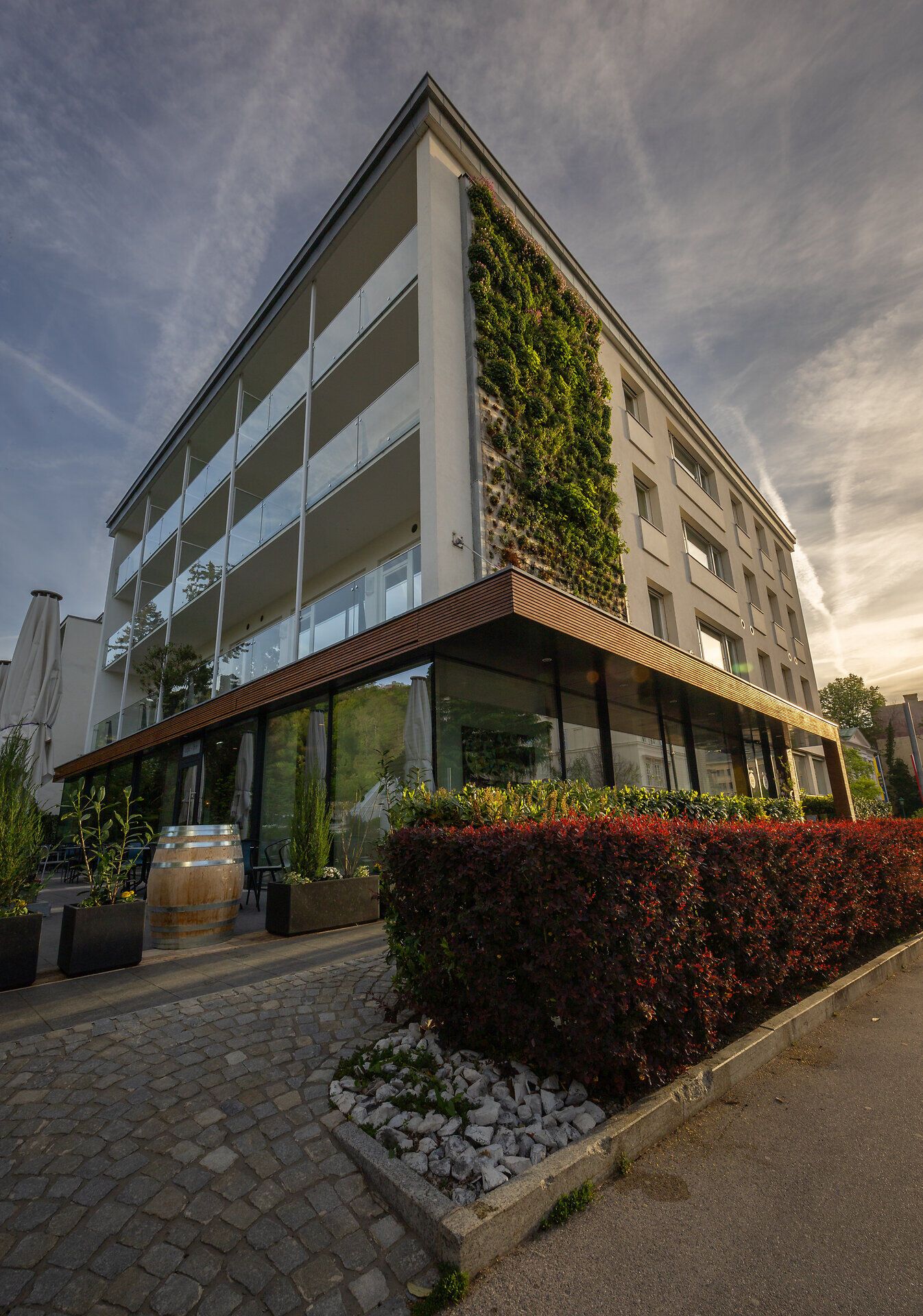 Ein stilvoll eingerichtetes Hotelzimmer mit einem großen roten Schuh als Bücherregal, antiken Stühlen, einem Tisch und einer Stehlampe.