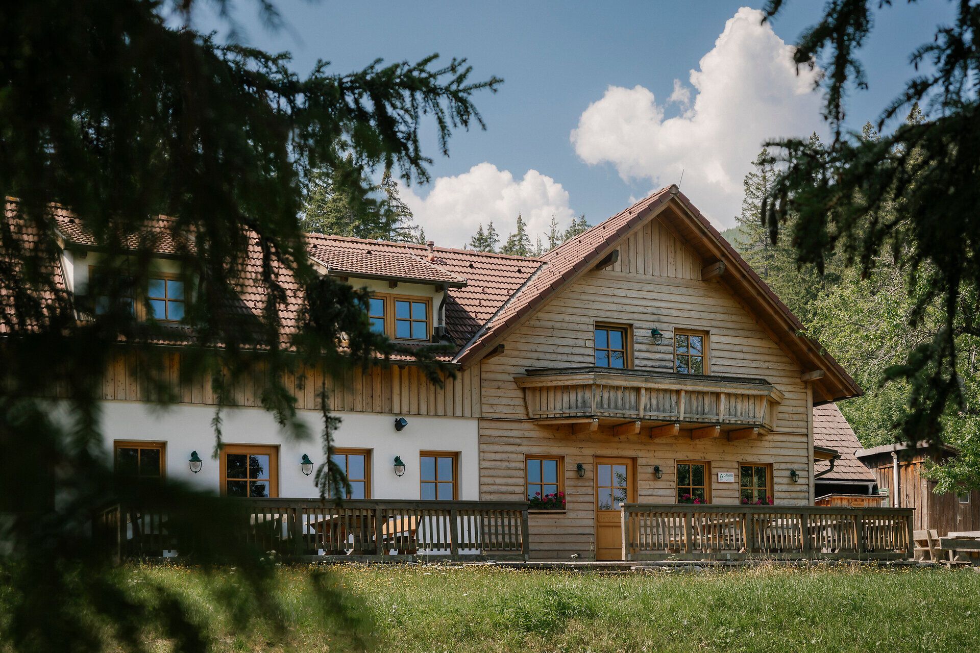Außenansicht der Hengsthütte am Schneeberg mit Holzbalkon und Terrasse