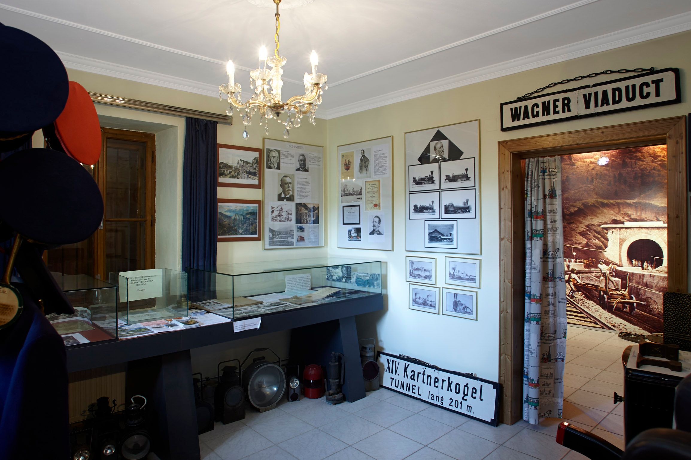 Innenansicht des Ghega-Museums mit Ausstellungsstücken und Fotos.