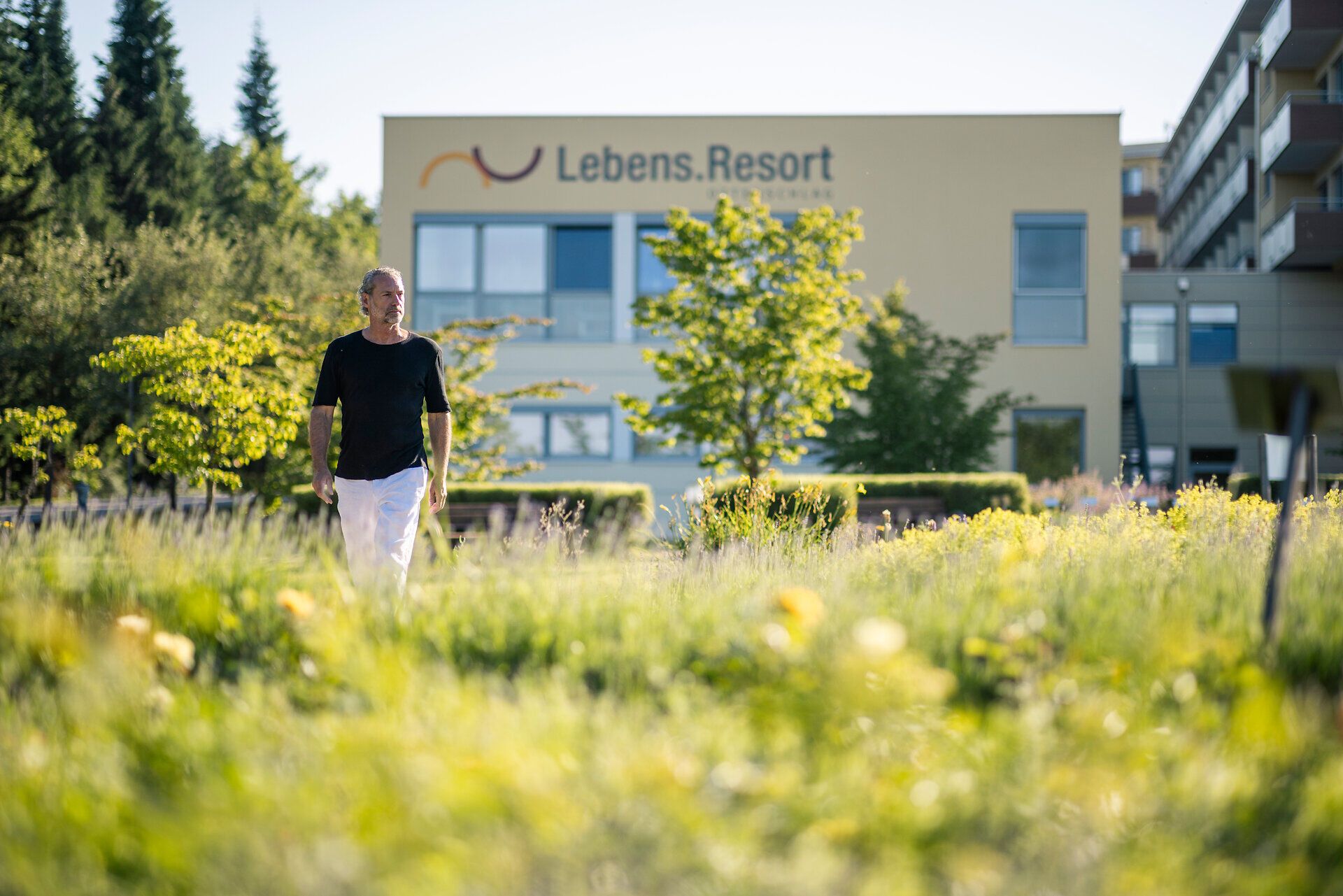 Ein Mann spaziert im Garten des Lebens.Resorts Ottenschlag im Waldviertel.
