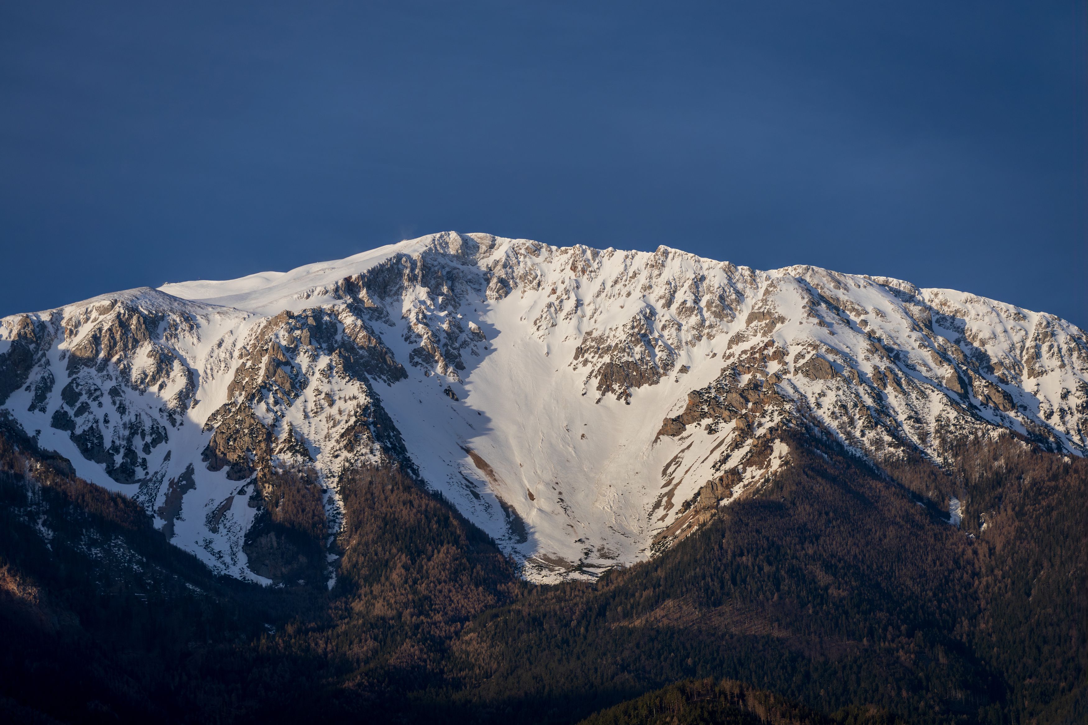Schneebedeckter Berg unter blauem Himmel.