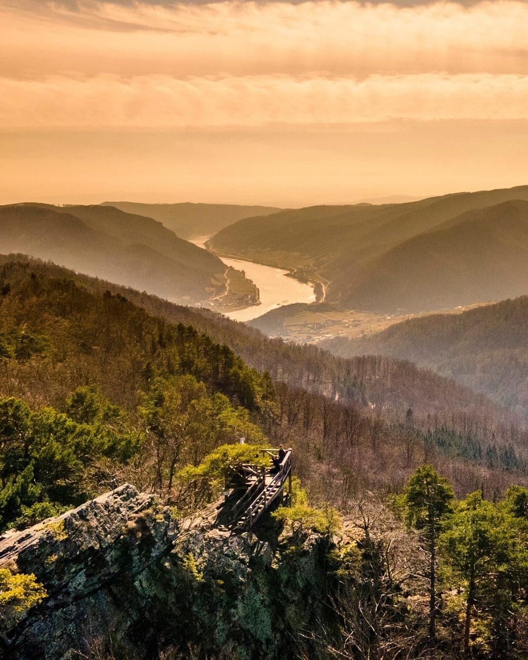 Aussicht von der Buschandlwand auf ein Flusstal bei Sonnenuntergang.