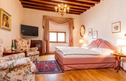 In einem eleganten Zimmer mit einem Hauch von Nostalgie lädt die gemütliche Atmosphäre zum Entspannen ein. Die warmen Holztöne und die stilvolle Einrichtung schaffen einen perfekten Rückzugsort, um die Schönheit der Umgebung zu genießen.