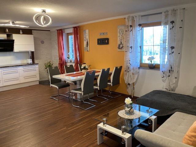 Moderne Wohnküche mit Esstisch, Stühlen, Sofa und Küchenzeile.