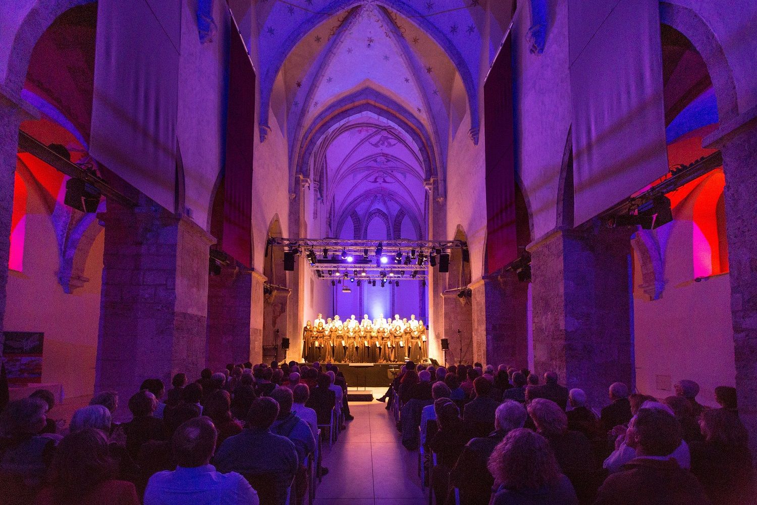 Innenansicht der Minoritenkirche in Krems während eines Konzerts mit beleuchtetem Chor.