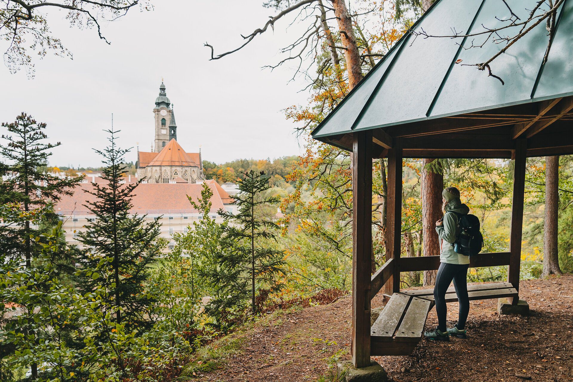 Umgeben von der bunten Pracht des Herbstes bietet der Gloriette Steig einen atemberaubenden Blick auf die majestätische Klosteranlage. Die frische, klare Luft und das sanfte Rascheln der Blätter laden zu einem entspannenden Spaziergang ein, während die Natur in warmen Gold- und Rottönen erstrahlt.