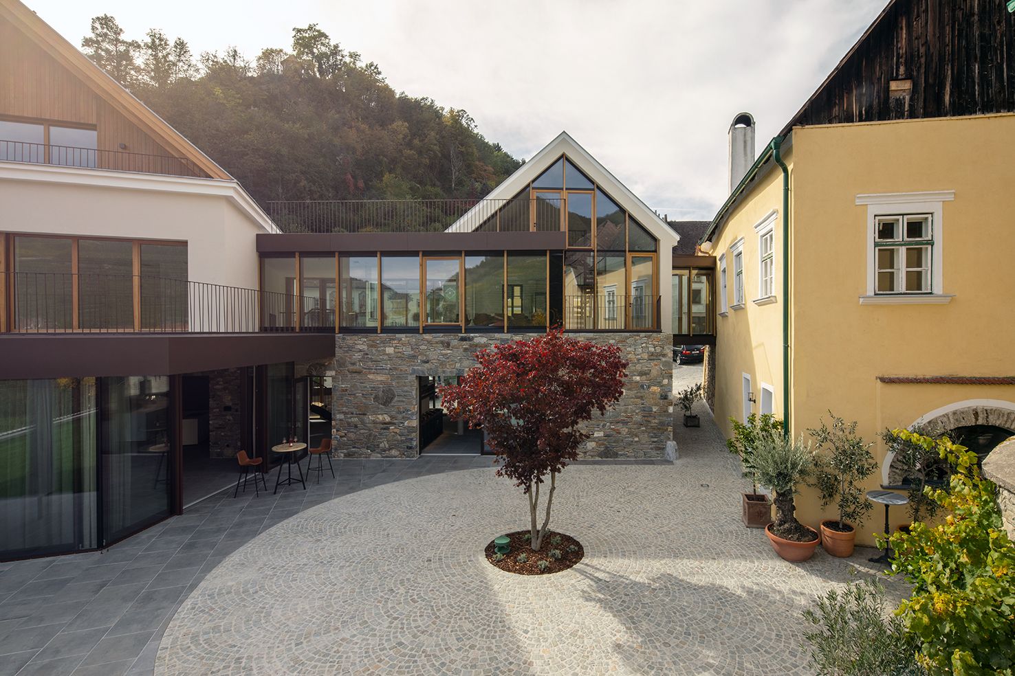 Gartenansicht des Mauritiushofs mit modernem Gebäude und gepflastertem Hof.