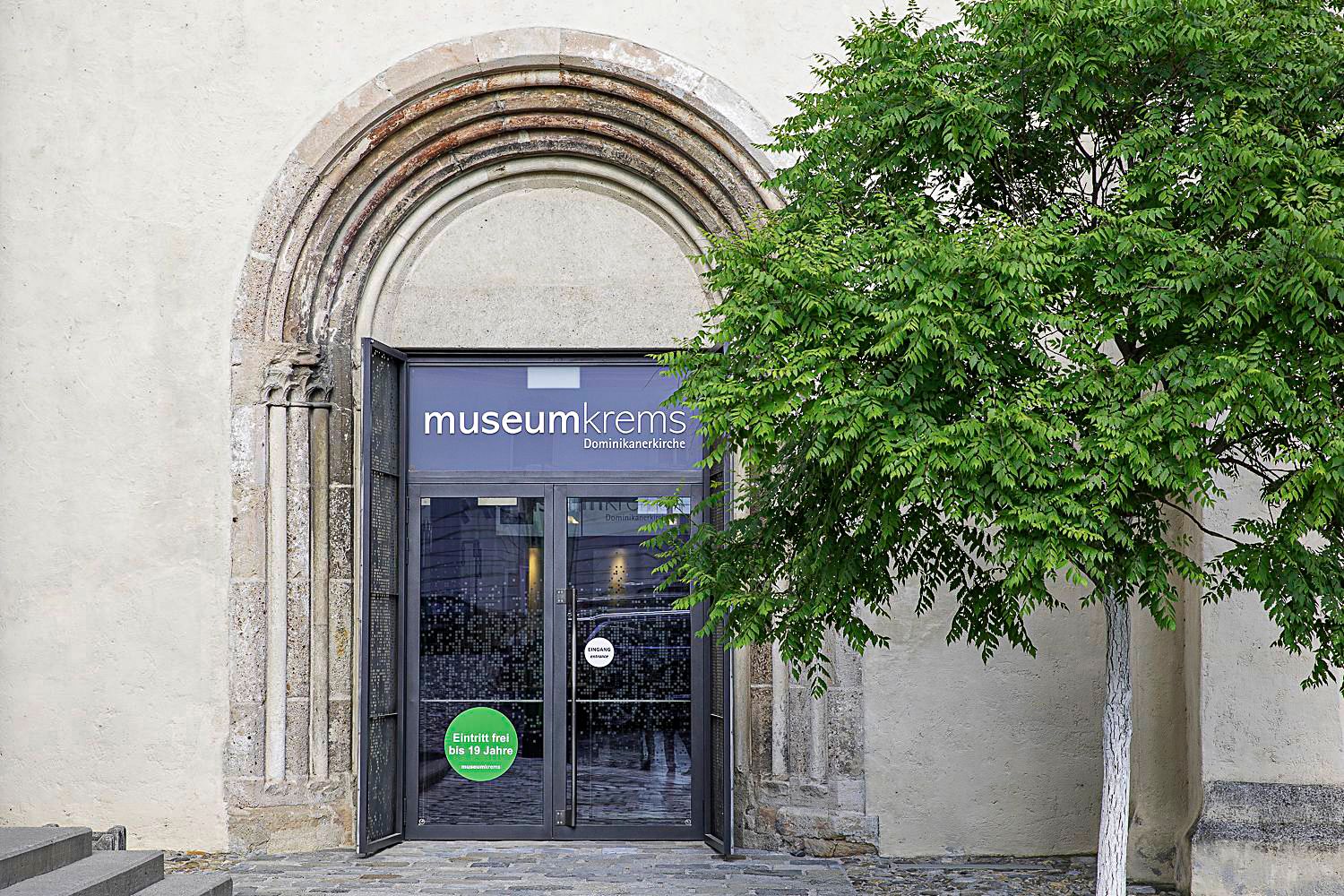Eingang des Museum Krems mit Baum daneben.