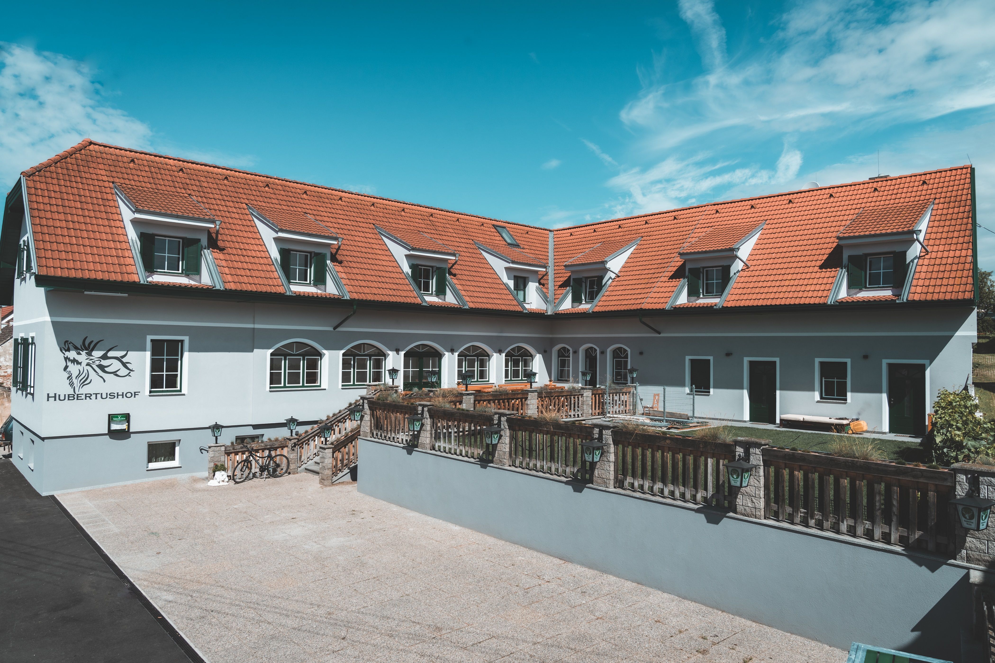 Ein Gebäude mit roten Dachziegeln und mehreren Dachfenstern, beschriftet mit 'Hubertushof'.