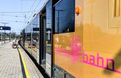 Die Wachaubahn schlängelt sich durch die malerische Landschaft, während die sanften Hügel und die glitzernde Donau im Hintergrund eine idyllische Kulisse bieten. Ein perfekter Ort, um die Schönheit der Region zu entdecken und die frische Luft der Natur zu genießen.