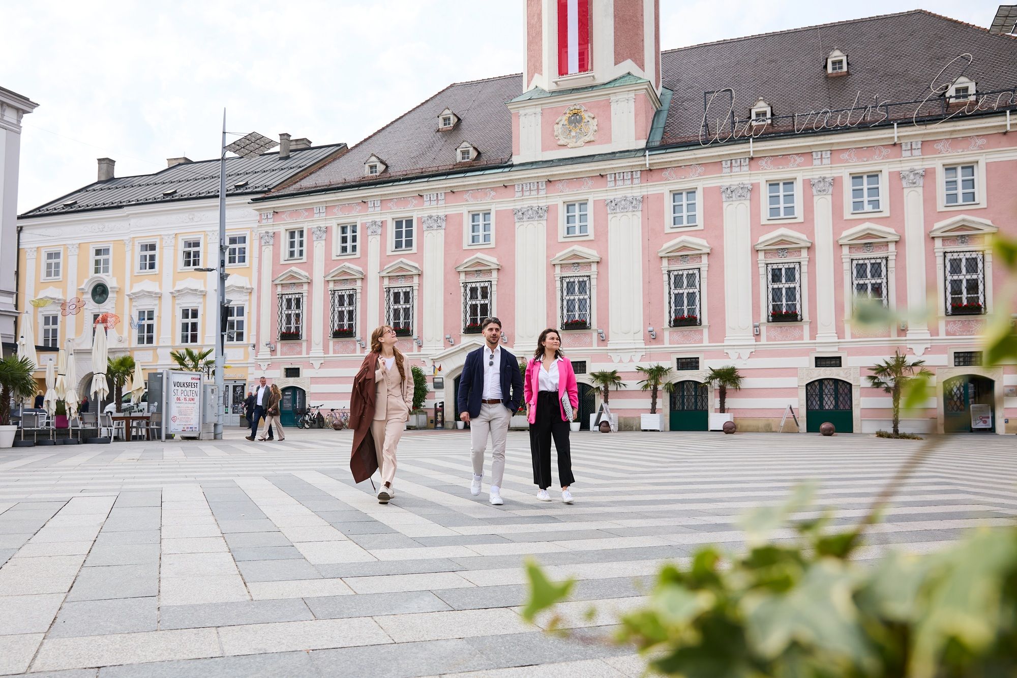 Drei Personen im Business Outfit vor dem barocken Rathaus von St. Pölten