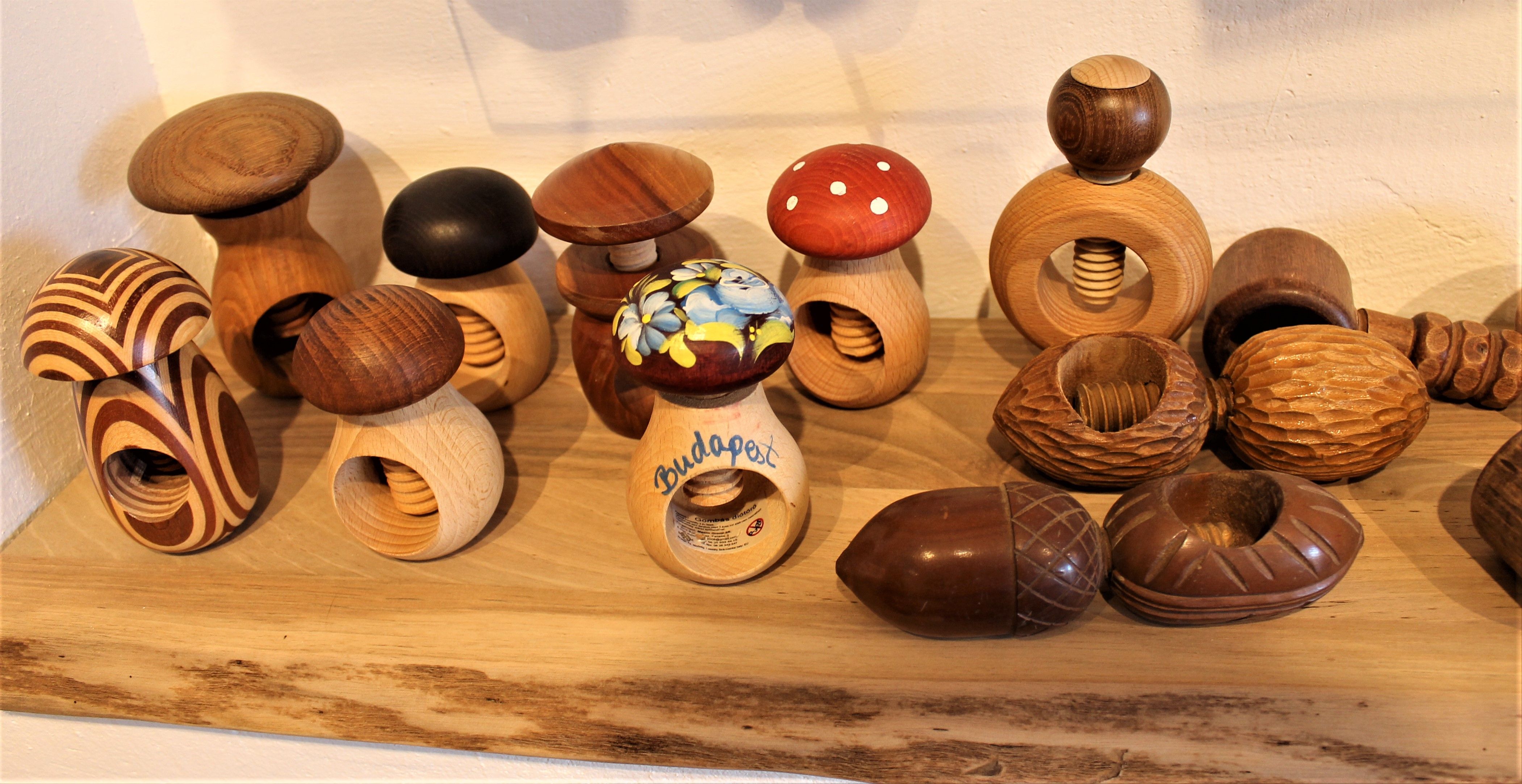 Verschiedene hölzerne Nussknacker in Pilzform auf einem Regal im Nusseum Krummnußbaum.
