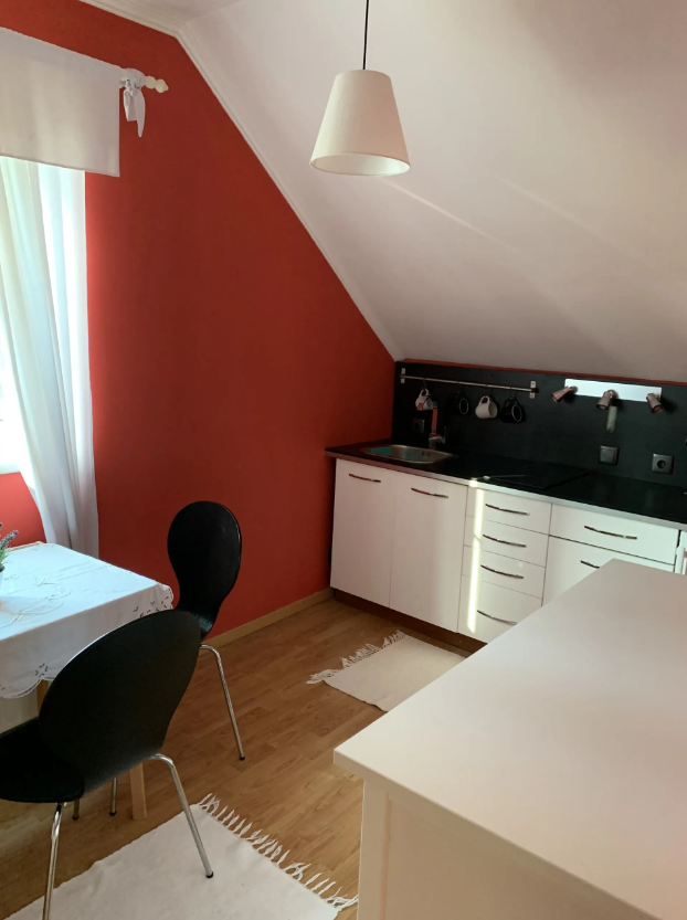 Küchenzeile mit Waschbecken und schwarzer Arbeitsfläche mit kleiner Sitzgruppe