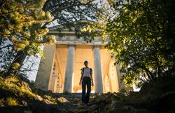 Frau wandert bergab, Husarentempel im Hintergrund