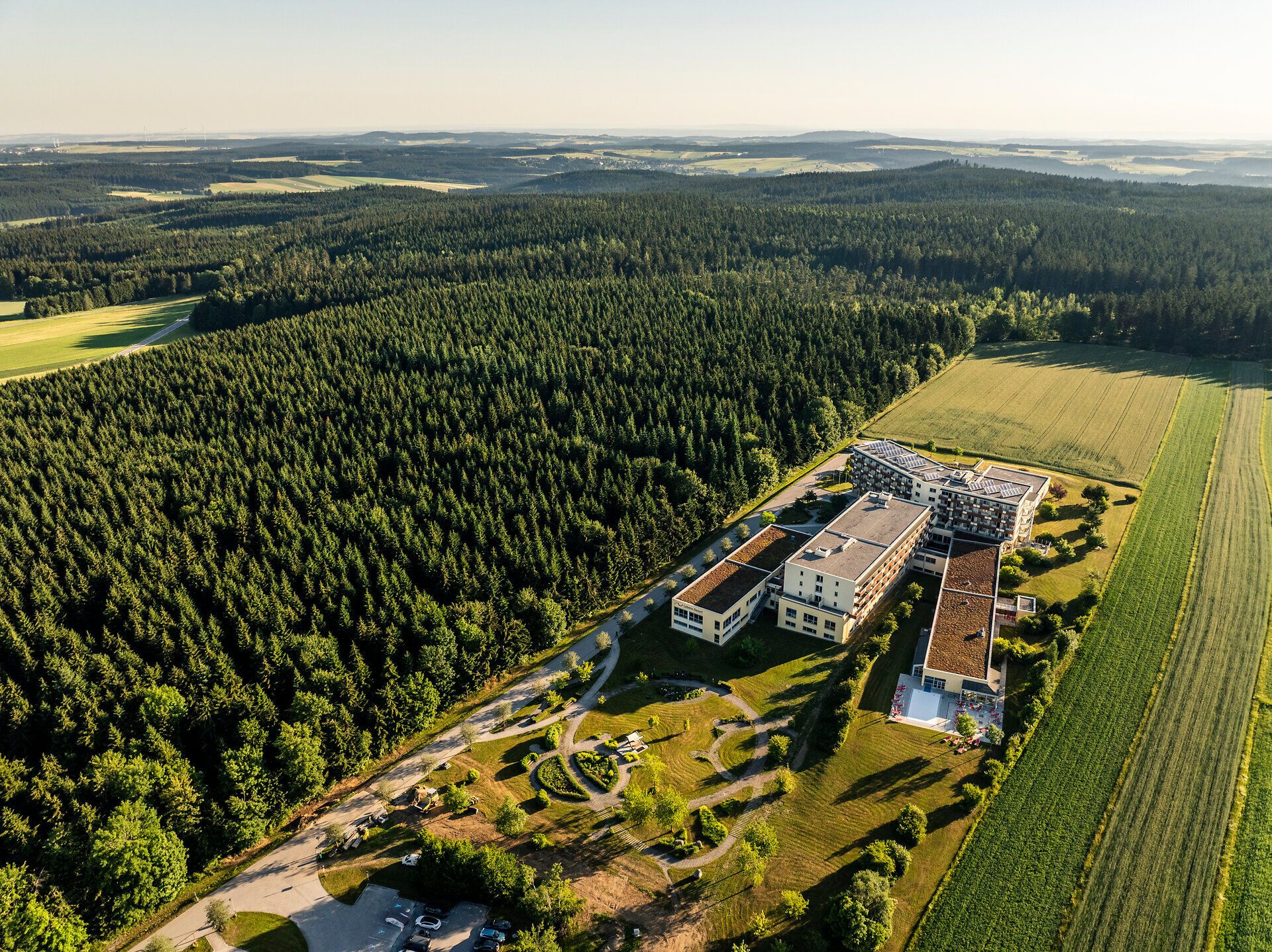Luftaufnahme des Lebens.Resorts Ottenschlag im Waldviertel, umgeben von Feldern und dichtem Wald.