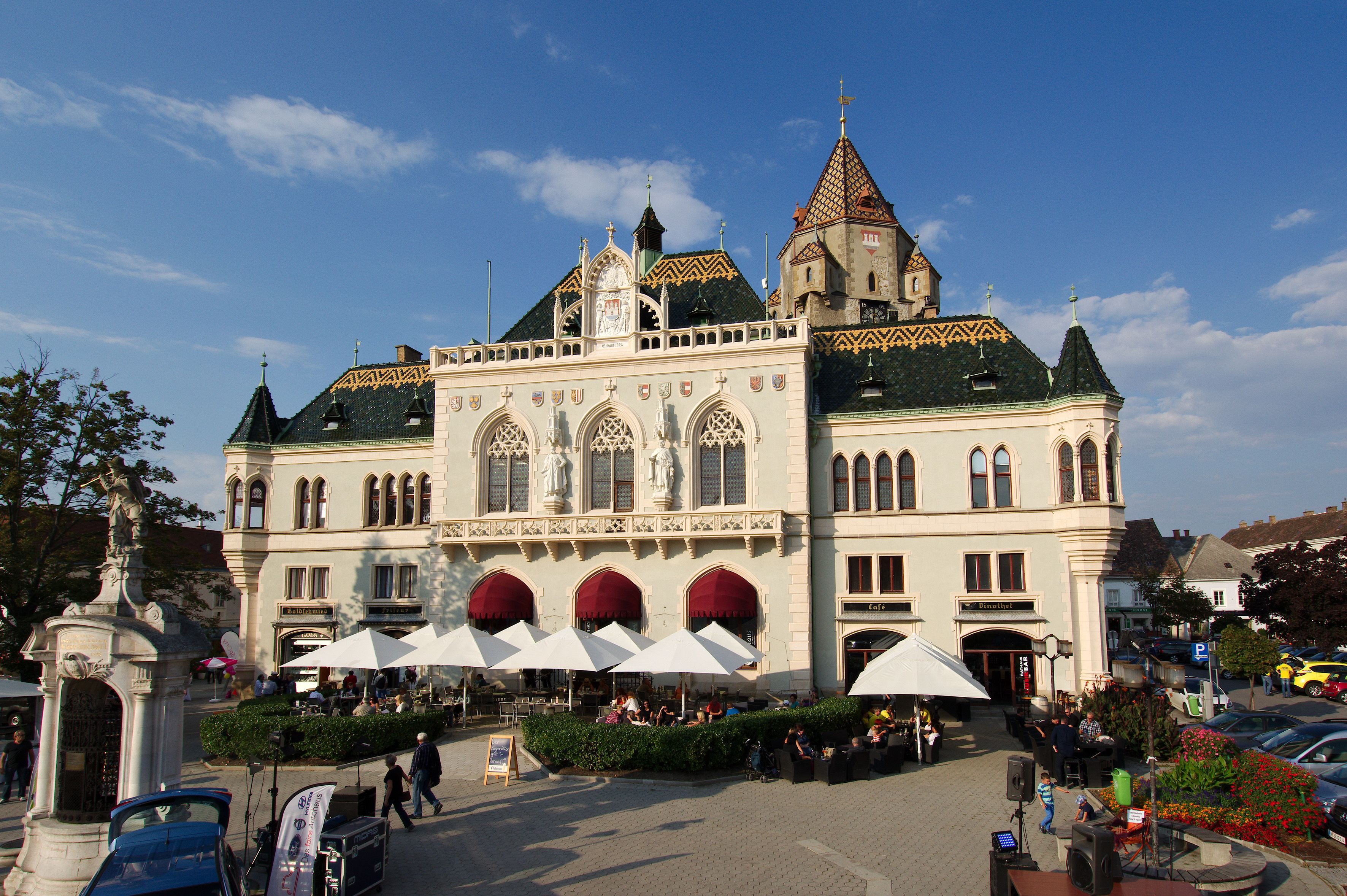 Rathaus Korneuburg mit markanter Architektur und Sonnenschirmen im Vordergrund.