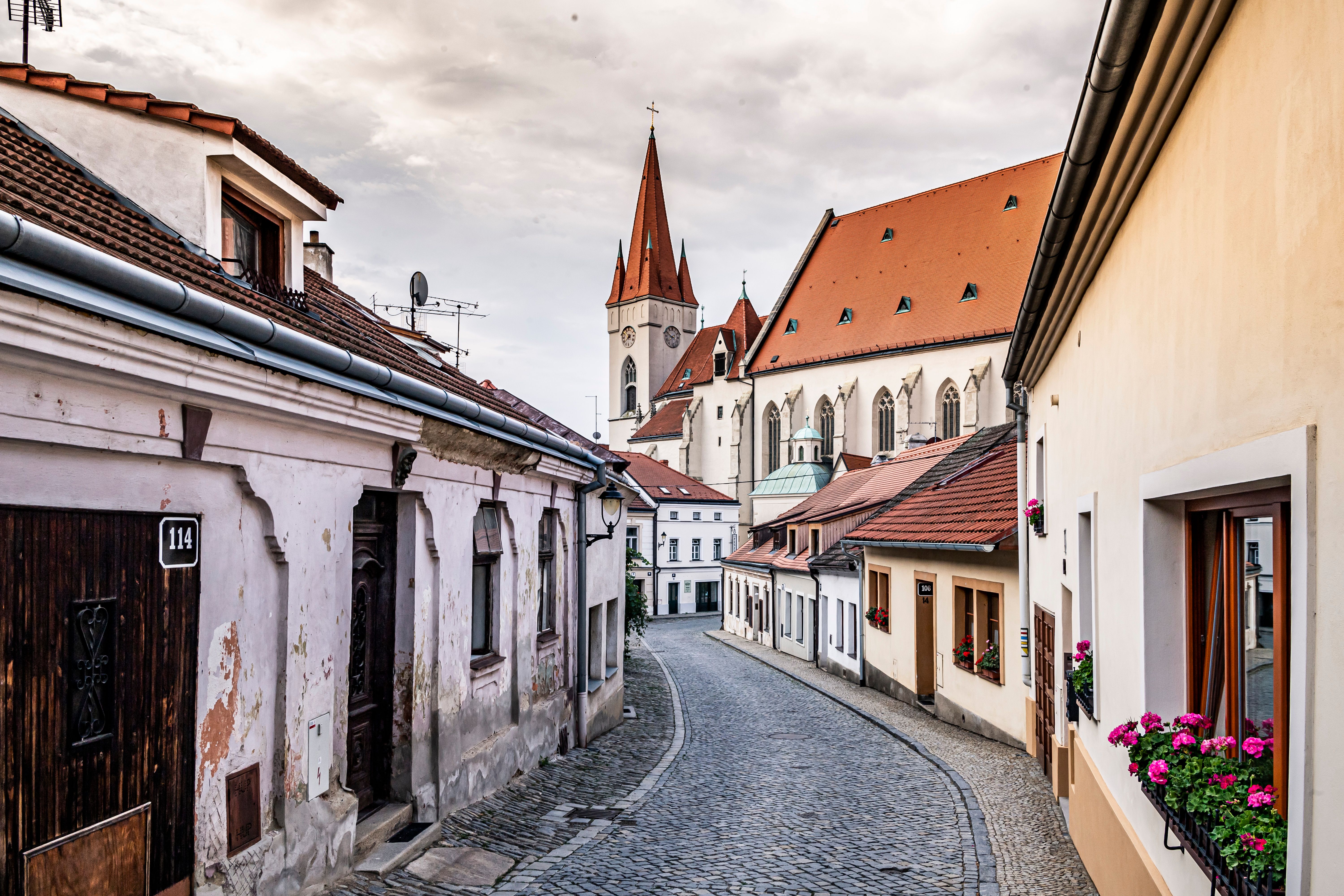 Eine malerische Straße in Znaim mit alten Häusern und einer Kirche im Hintergrund.