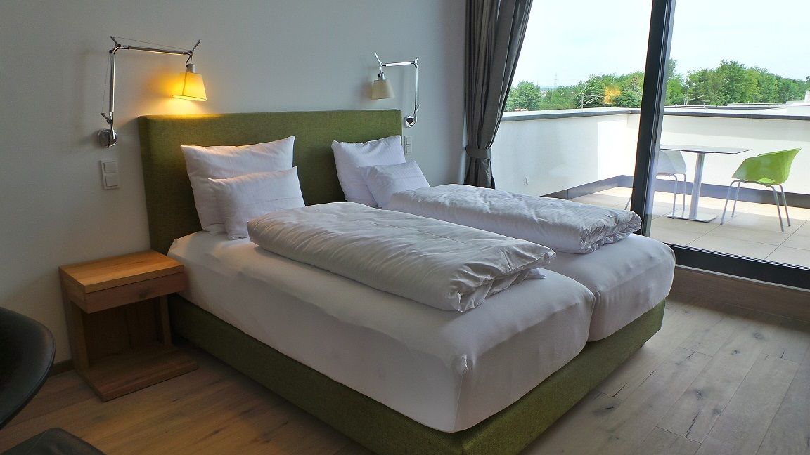 Modernes Schlafzimmer mit Doppelbett und Balkon.