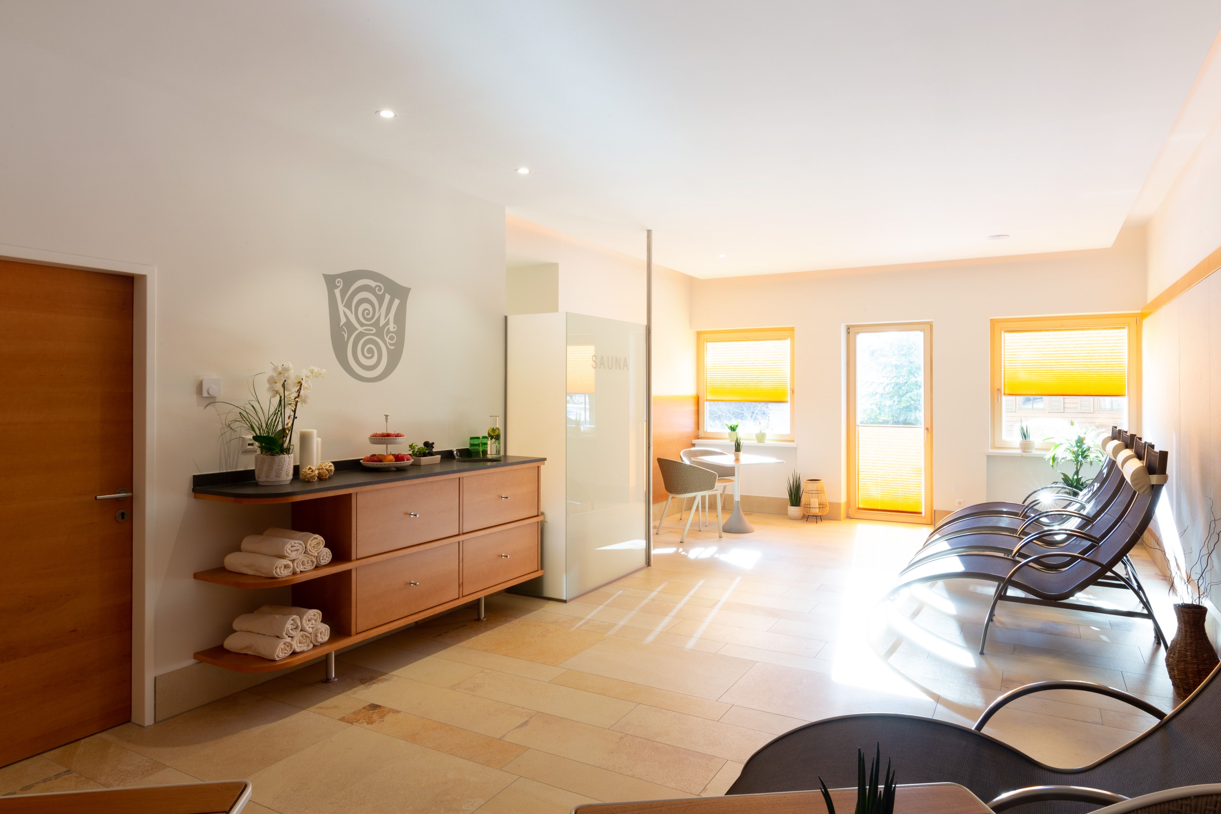 Moderner Wellnessbereich mit Liegestühlen, Sauna und Dekoration.