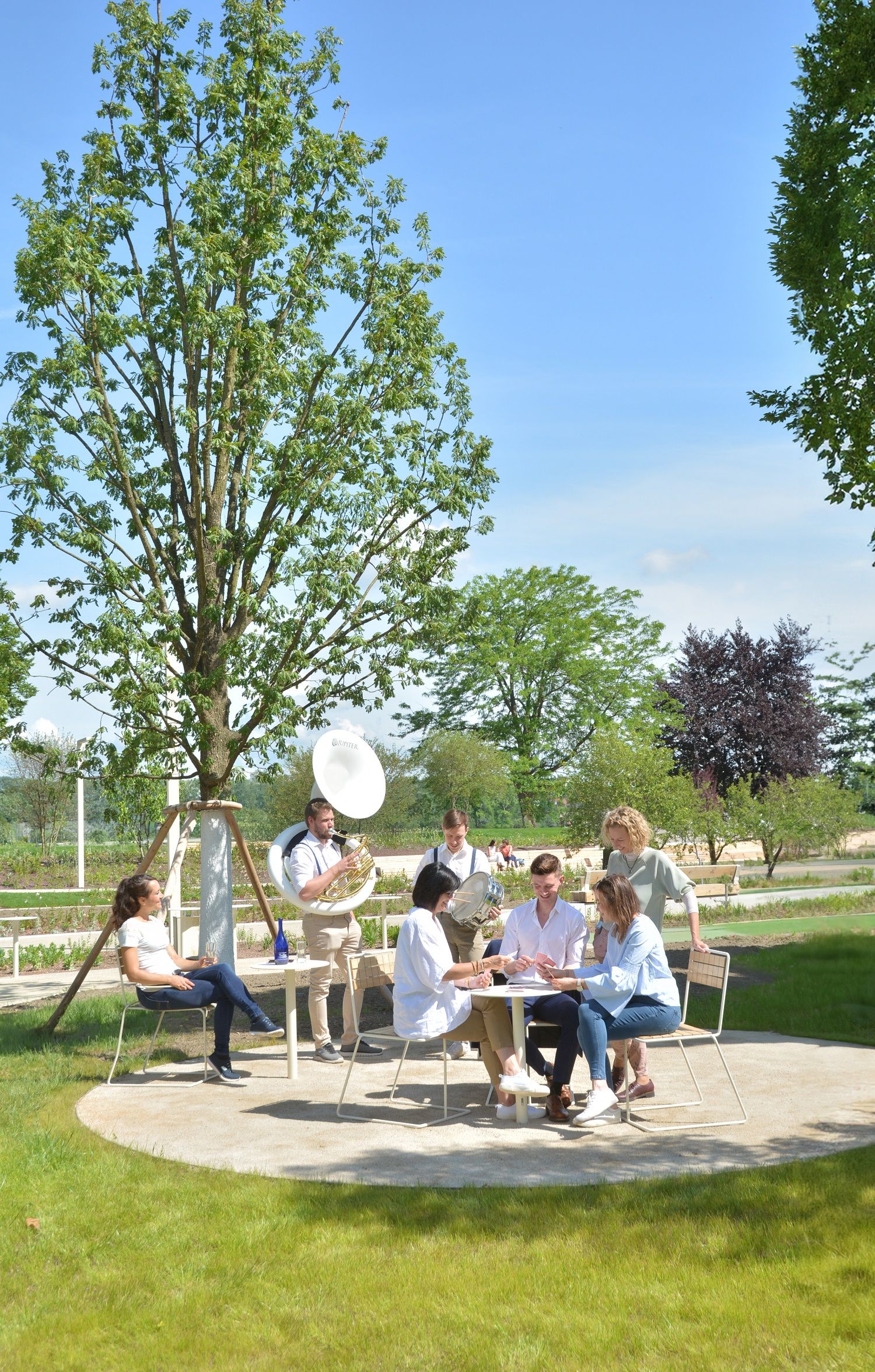 MEnschen Gruppe sitzend unterhält sich im Hintergrund spielt Kapelle Musik 