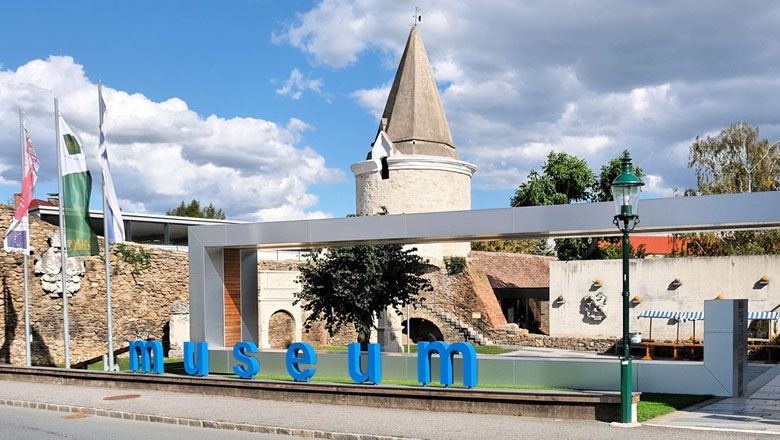 Eingang des Museums Horn mit modernem Schriftzug und historischem Turm im Hintergrund.