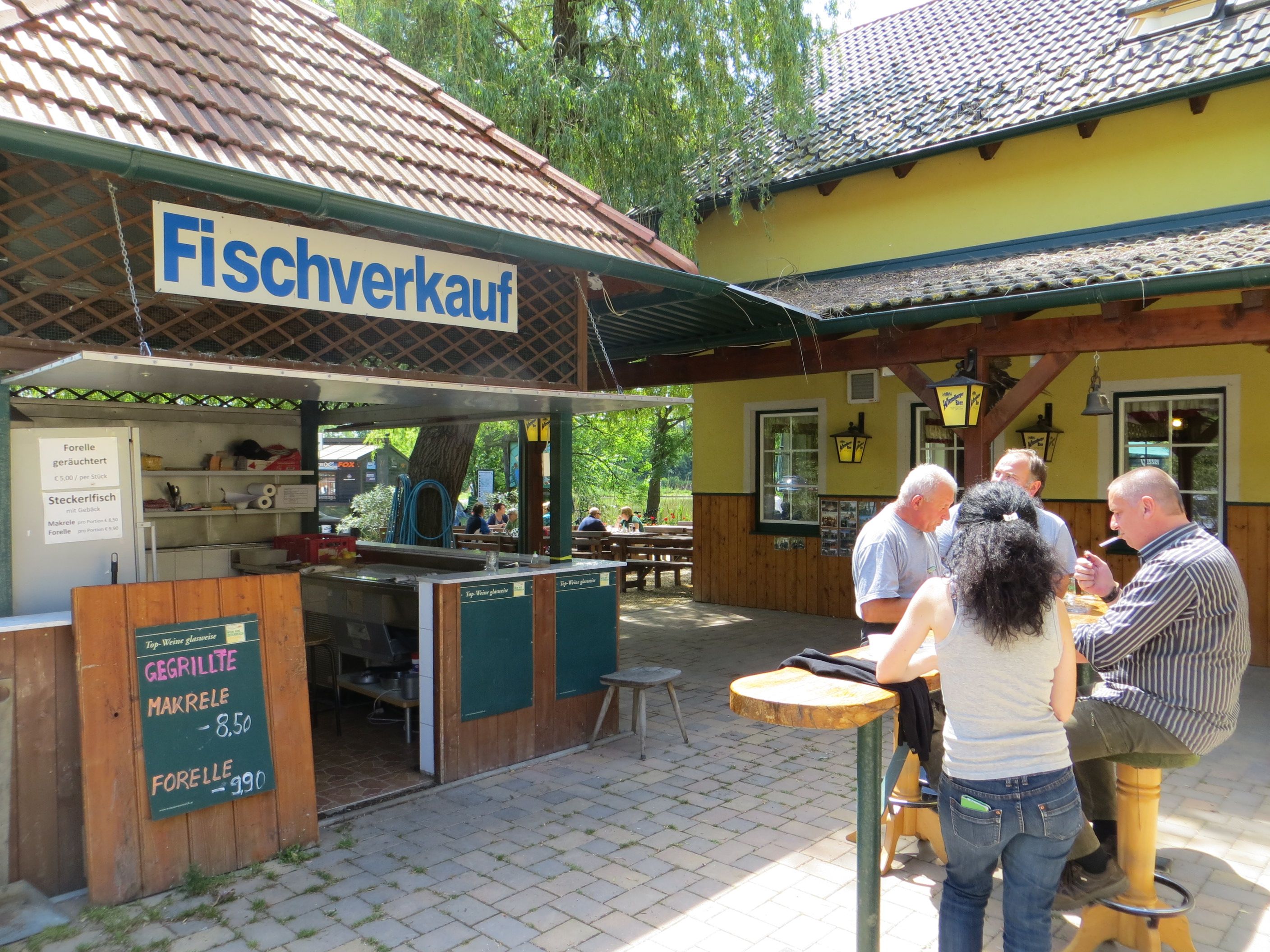 Ein Fischverkaufsstand mit Menschen, die an einem Tisch essen.