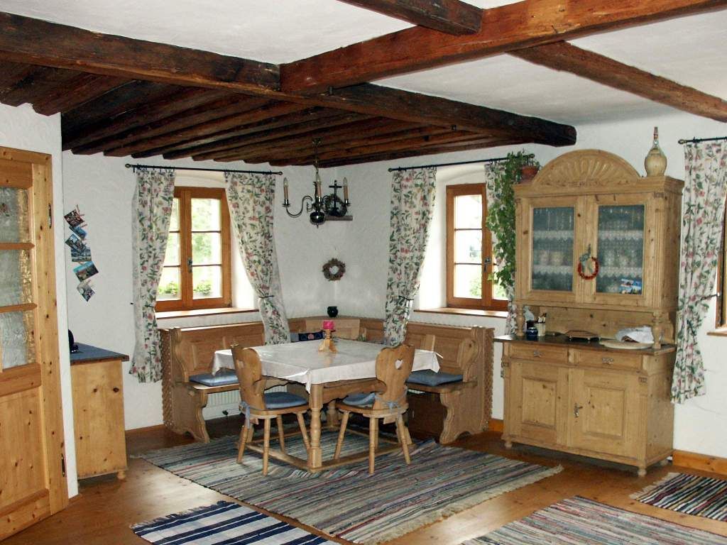 Rustikale Essecke mit Holzmöbeln und Teppichen in einem Ferienhaus.