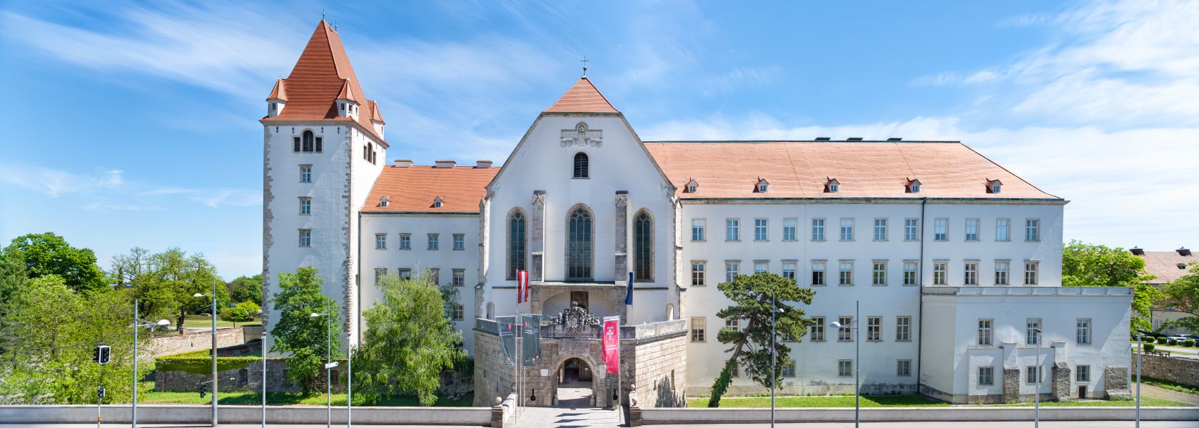 Frontansicht der Militärakademie Wiener Neustadt mit blauem Himmel.
